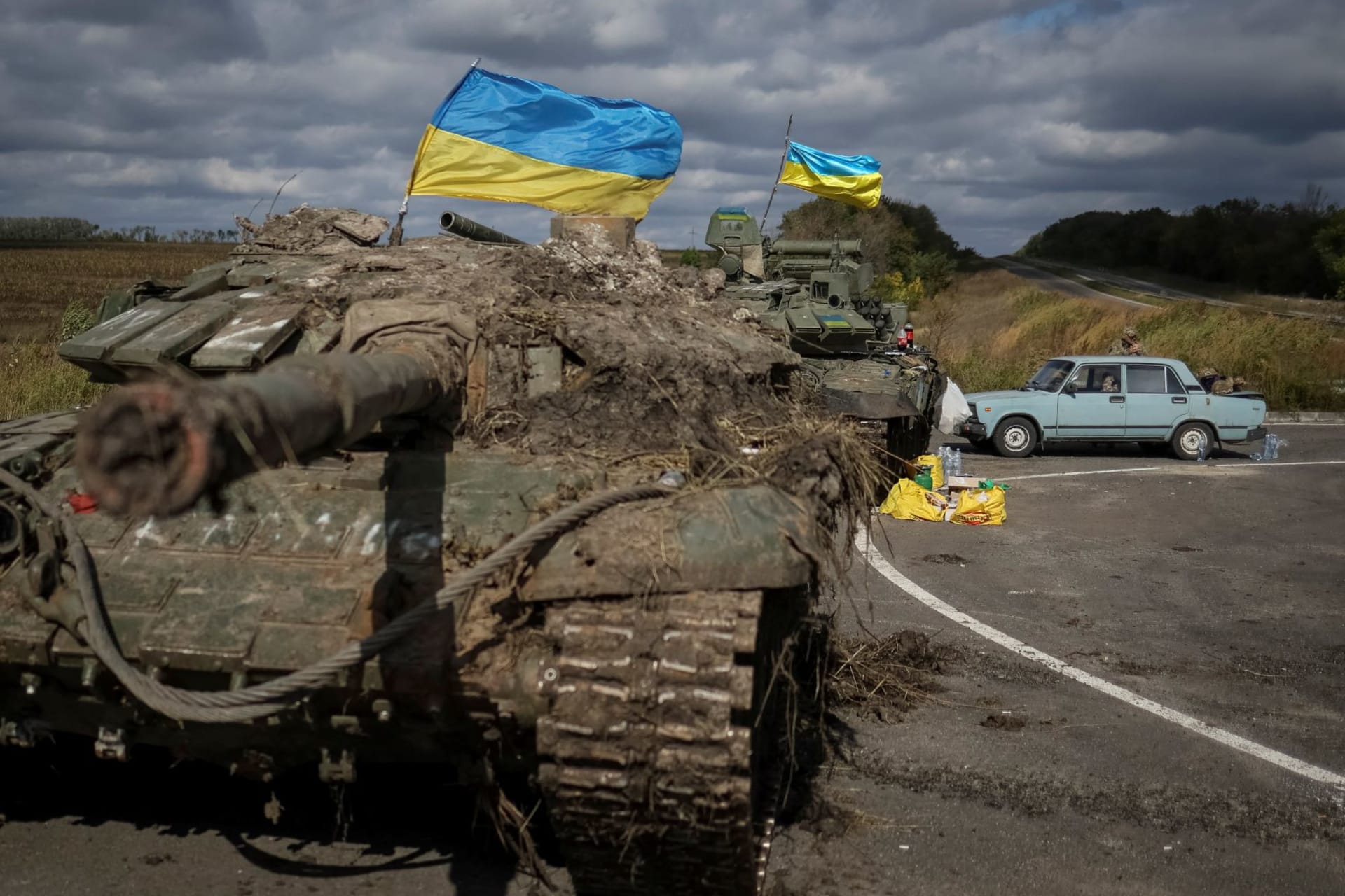 <p>Ukranian flags fly above captured Russian tanks on September 19, 2022, near the town of Izium.</p>
