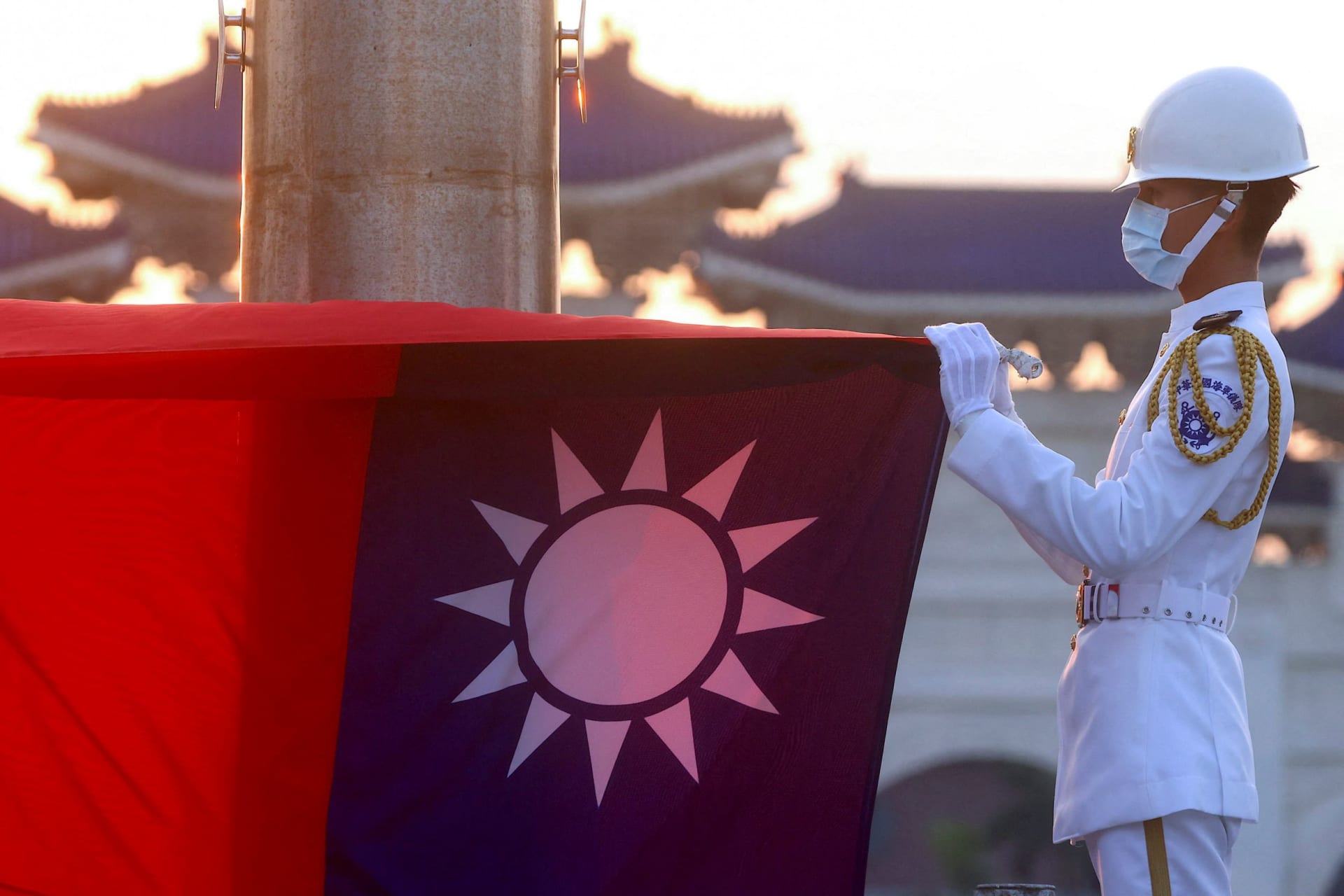 <p>Honor guards lower the Taiwan flag during sunset hours at Liberty Square in Taipei.</p>
