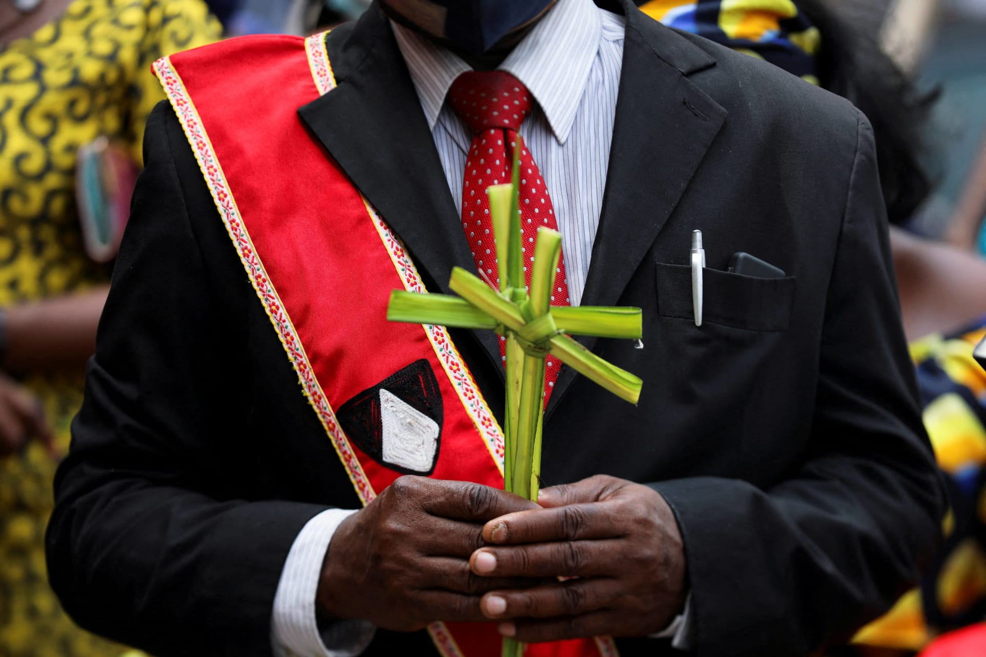 <p>A Catholic devotee holds palm crosses to be blessed before a Palm Sunday mass at St. Dominic Catholic Church in Lagos, Nigeria on April 10, 2022</p>
