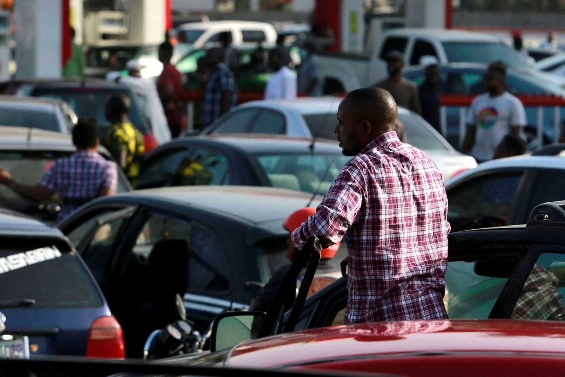 <p>A Nigerian man gazes from his car in the midst of several vehicles seeking to fill gas at a station in Abuja. </p>
