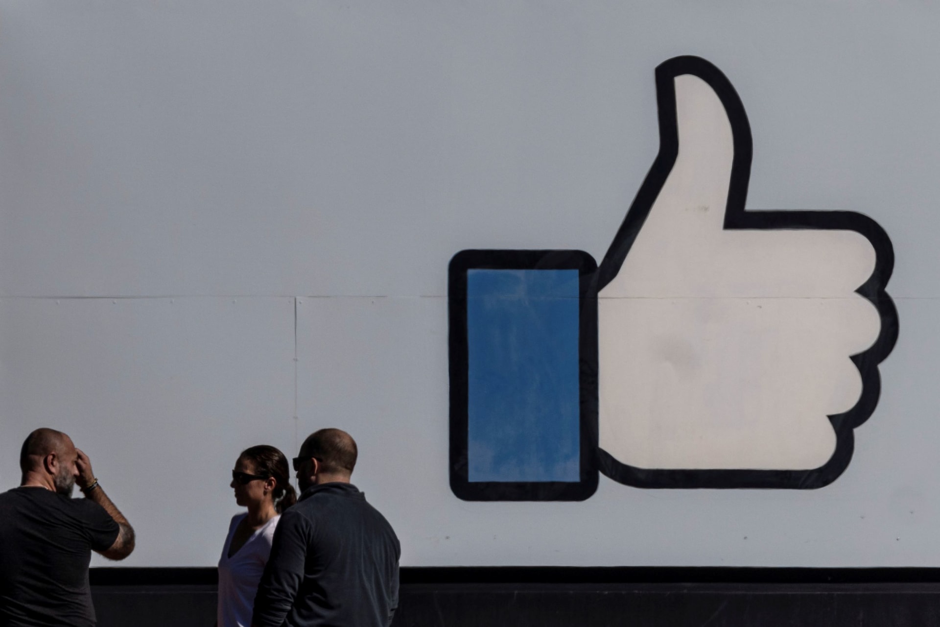<p>People stand in front of the entrance sign to Facebook headquarters in Menlo Park, California on October 27, 2021. </p>
