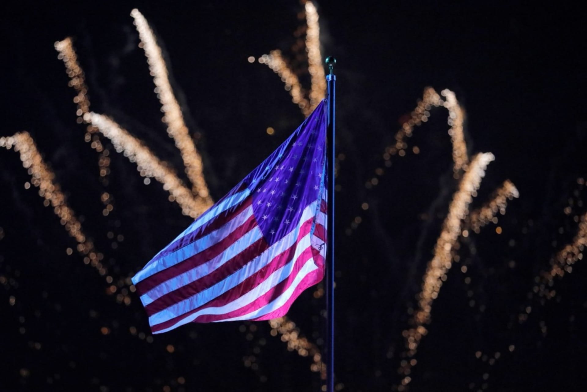 <p>Fireworks explode behind a U.S. flag during New York City’s Independence Day celebrations on July 4, 2021.</p>
