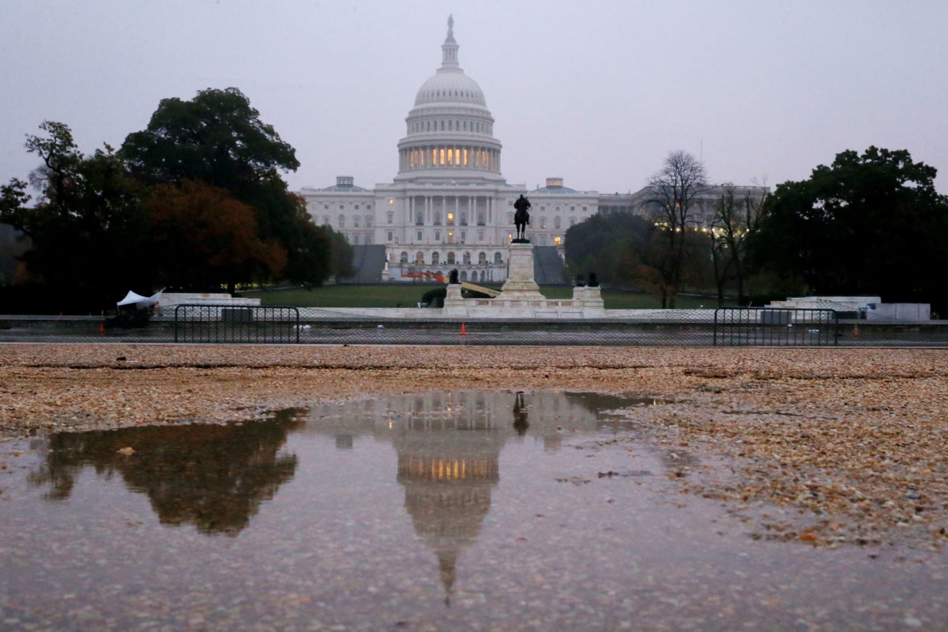 <p>The U.S. Capitol building is seen reflected in a puddle at sunrise on November 6, 2018.</p>
