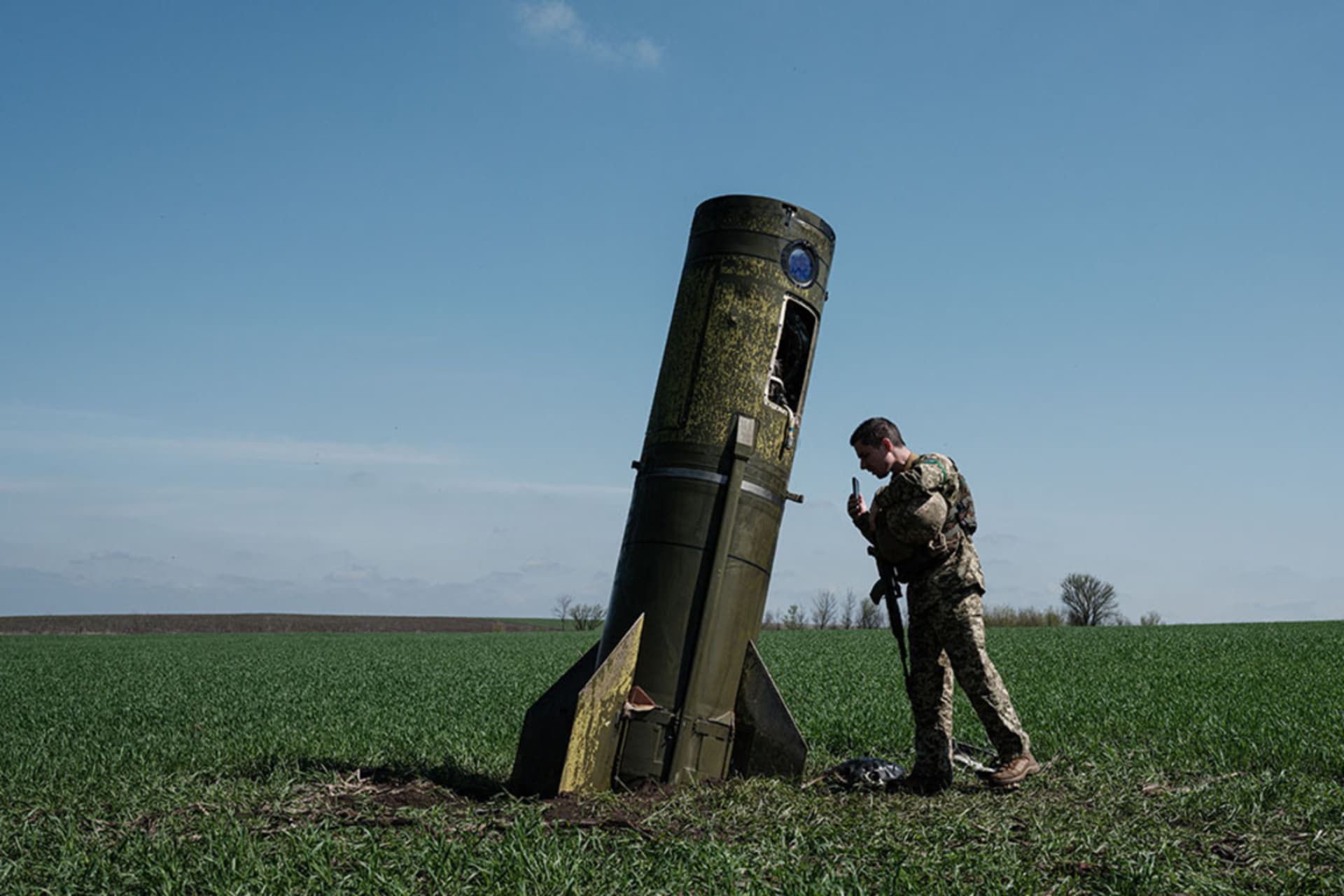 <p>A Ukrainian serviceman looks at a Russian ballistic missile booster that fell in a field in eastern Ukraine.</p>
