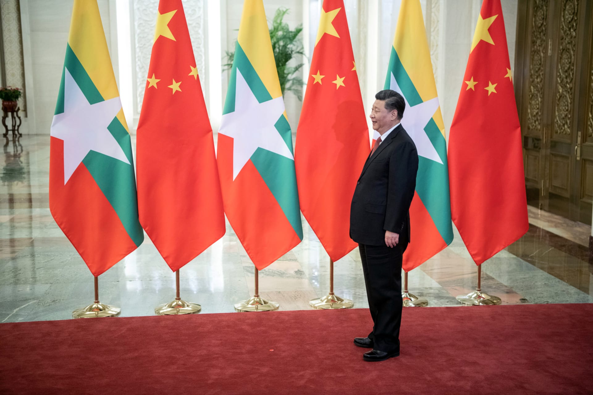 <p>Chinese President Xi Jinping in front of China and Myanmar’s flags, 2019.</p>

