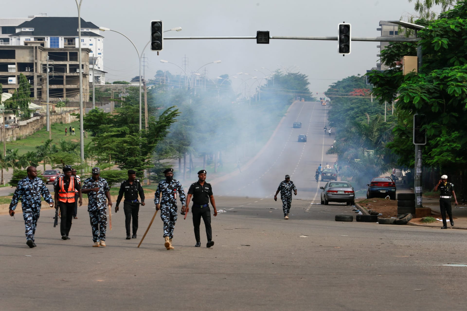 <p>Members of the Nigeria police force walk after chasing protesters away during a June 12 Democracy Day rally in Abuja, Nigeria on June 12, 2021.</p>
