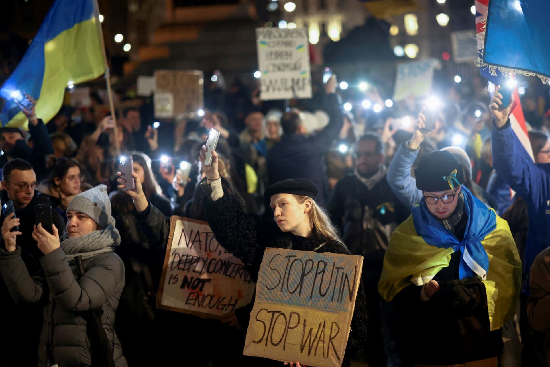 <p>People hold up lit up phones during a protest against Russia’s invasion of Ukraine, at Trafalgar Square in London, Britain on March 4, 2022.</p>
