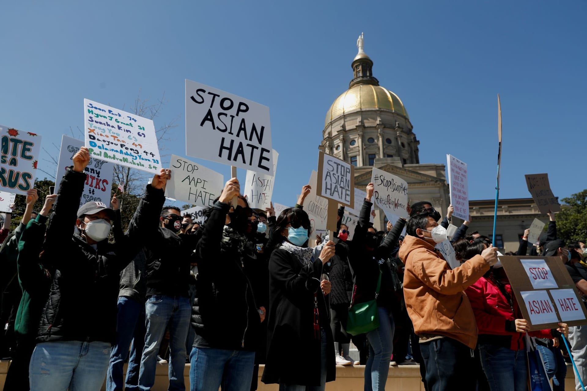 <p>People hold placards during a “Stop Asian Hate” rally on March 20, 2021, following deadly shootings at a spa in Atlanta, Georgia.</p>
