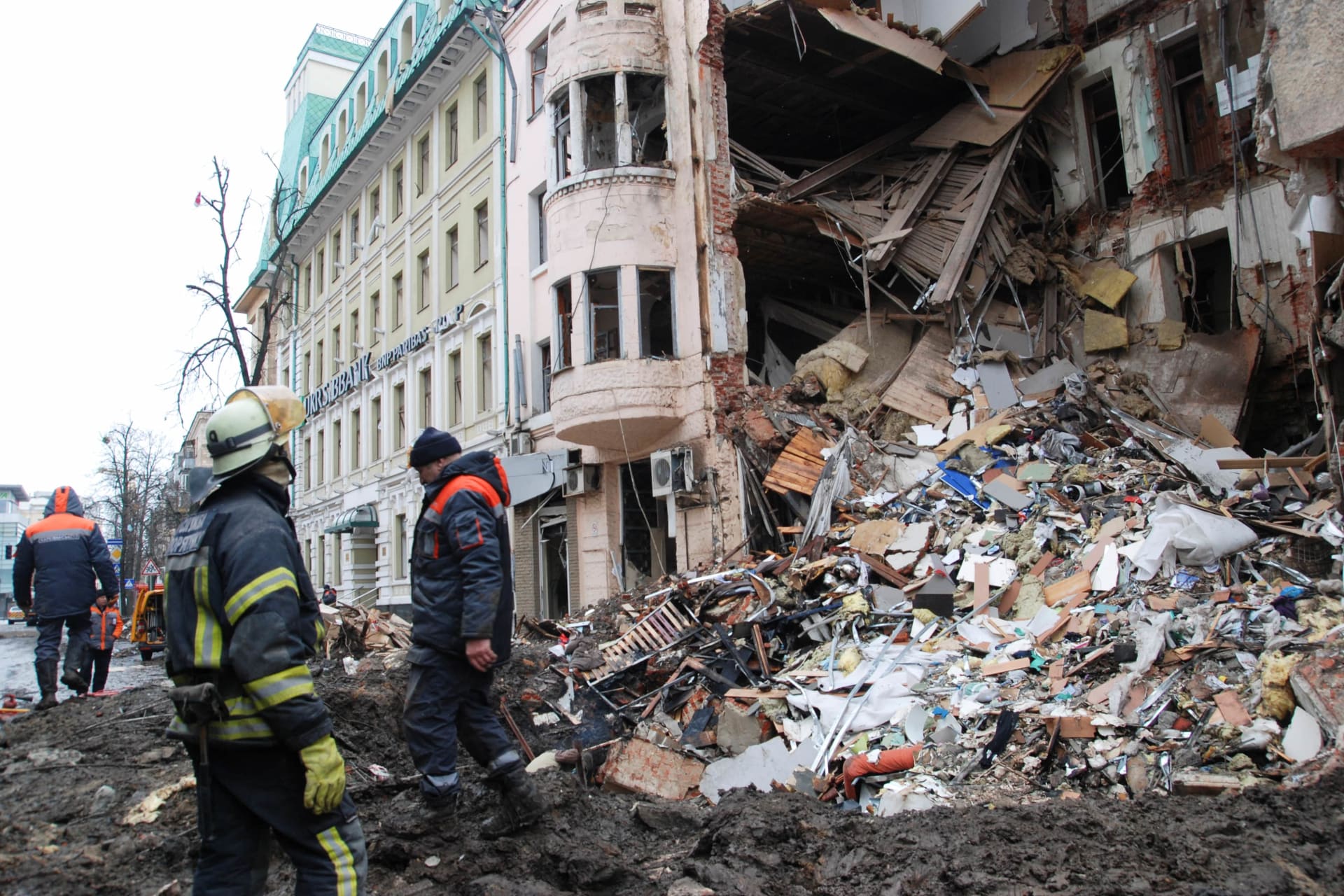 <p>Rescue workers stand near a heavily damaged building, amid Russia’s invasion of Ukraine, in Kharkiv, Ukraine on March 14, 2022.</p>