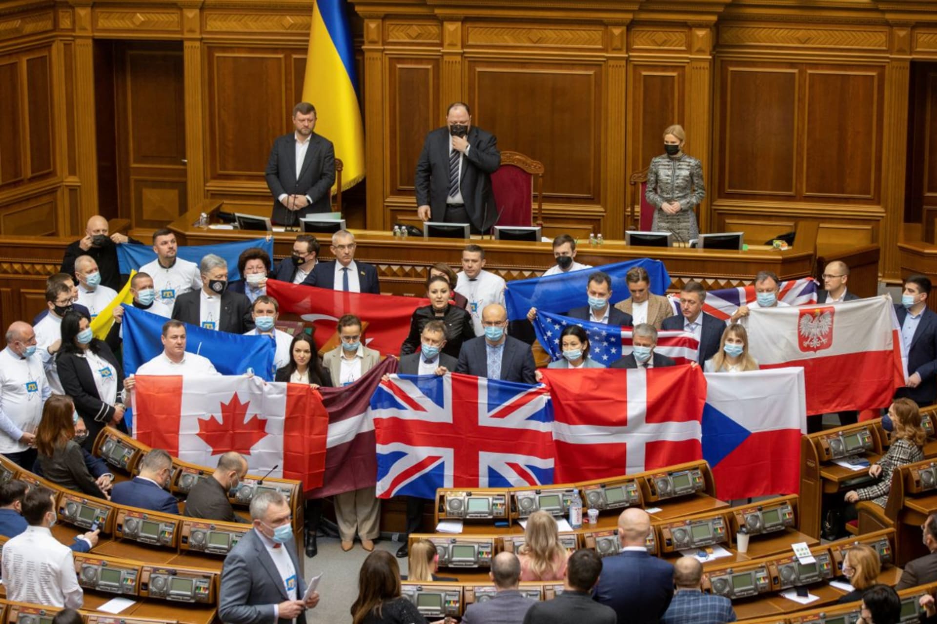 <p>Ukrainian lawmakers hold state flags of Ukraine’s partners to show their appreciation of political support and military aid during a session of parliament in Kyiv, Ukraine February 1, 2022.</p>
