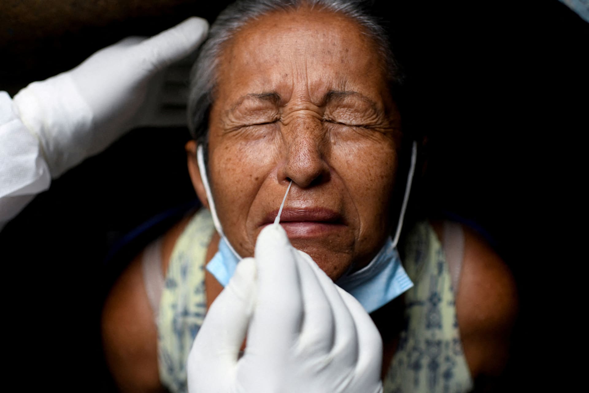 <p>A health-care worker in Rio de Janeiro takes a swab sample to test a person for COVID-19.</p>
