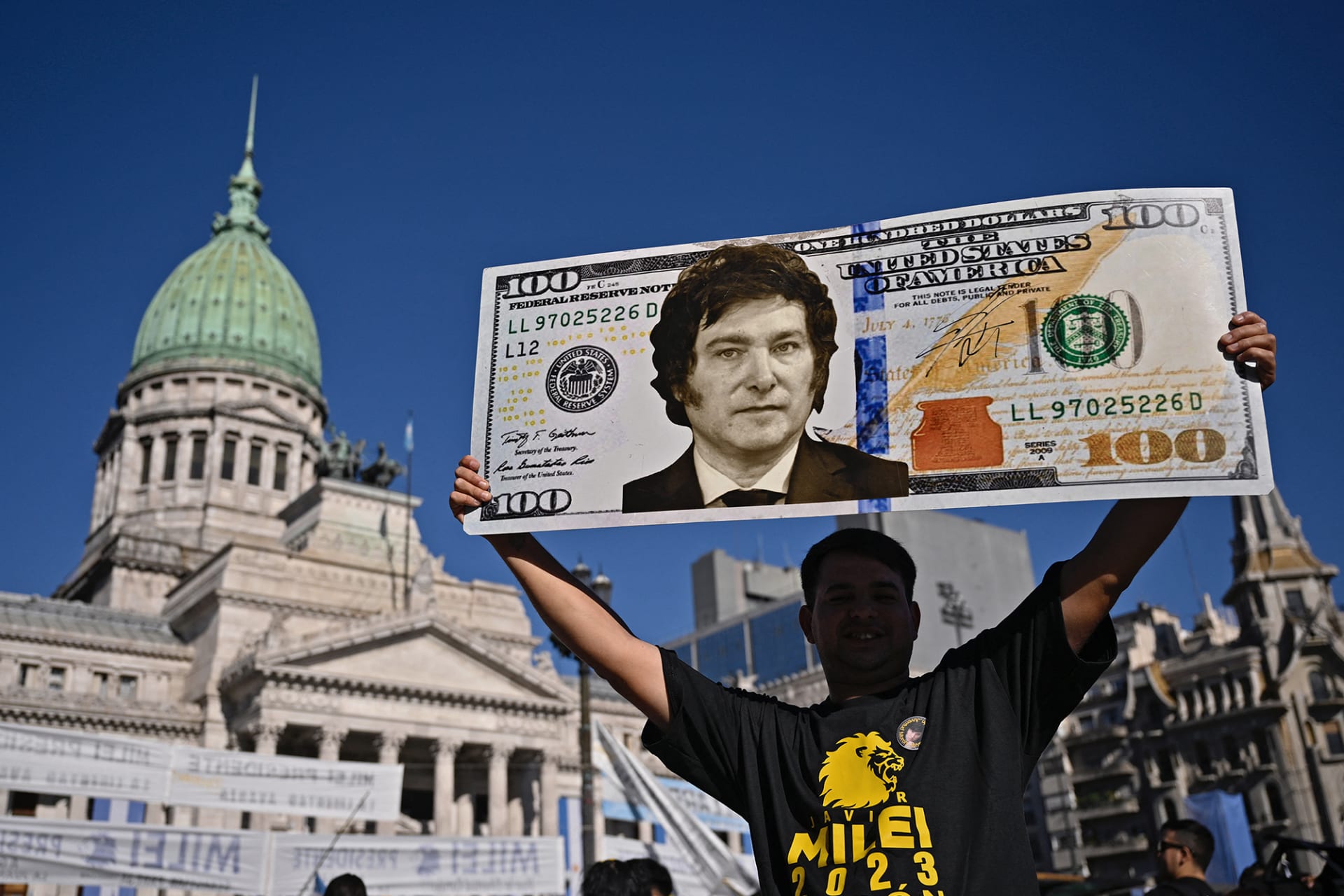 <p>A supporter holds up a $100 bill sign of then President-Elect Javier Milei in December 2023.</p>
