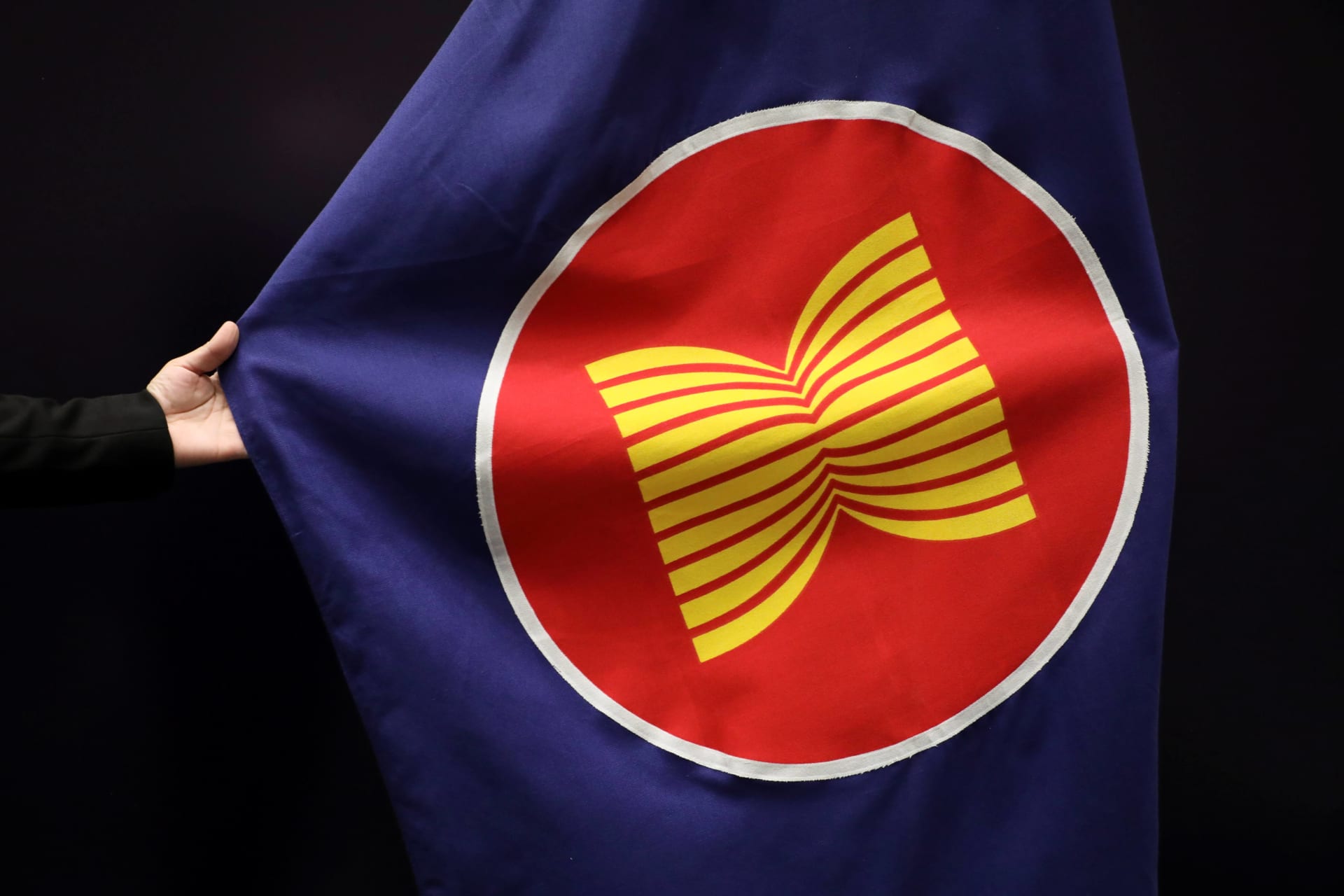 <p>A worker adjusts an ASEAN flag at a meeting hall in Kuala Lumpur, Malaysia, on October 28, 2021.</p>
