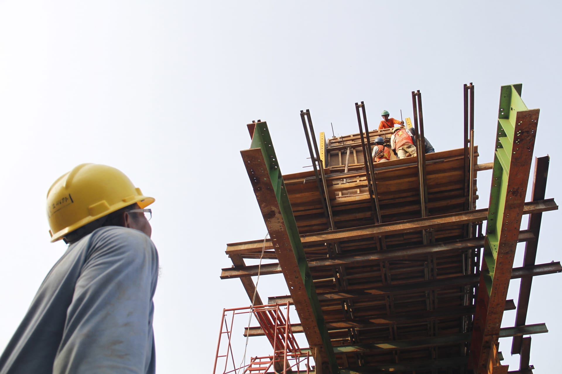 <p>Workers stand on top of a new highway under construction in east Jakarta, Indonesia November 4, 2015.</p>
