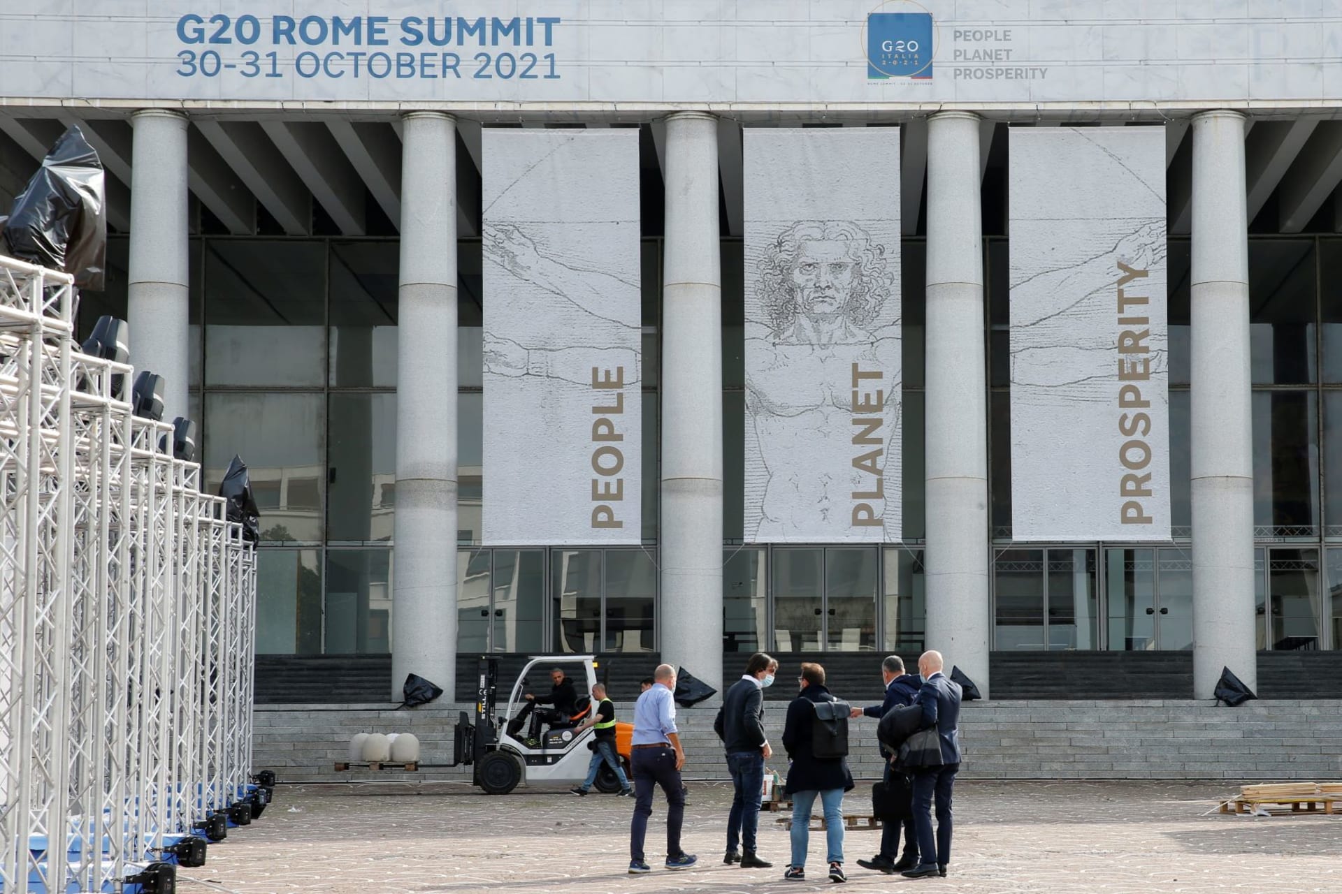<p>People stand in front of the G20 media center at the Palazzo dei Congressi in Rome, Italy, which will host the G20 summit from October 30-31 on October 22, 2021.</p>
