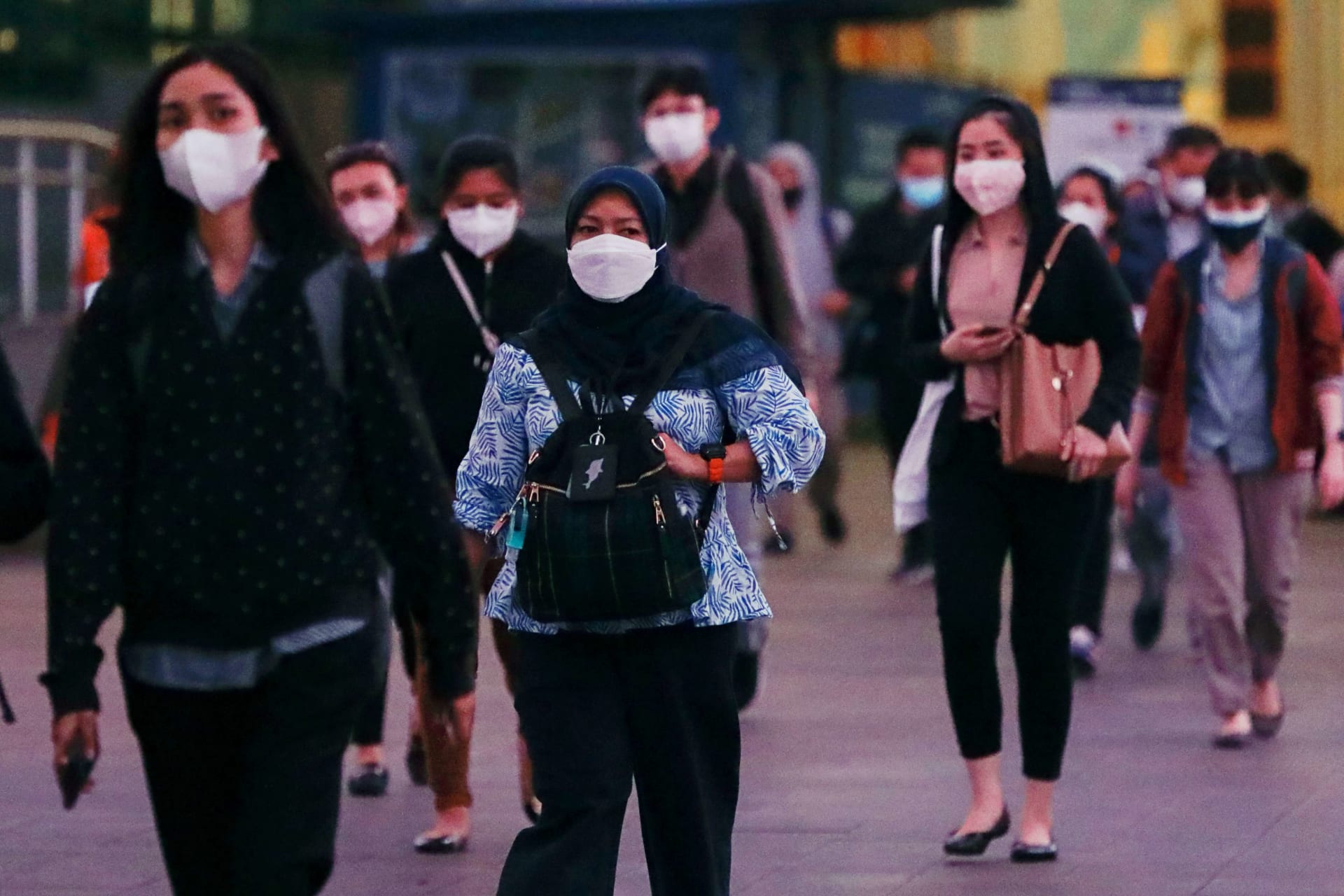 <p>People wearing protective face masks walk on a road during rush hour as the government extends restrictions to curb the spread of coronavirus disease (COVID-19) in Jakarta, Indonesia, on September 21, 2021. </p>
