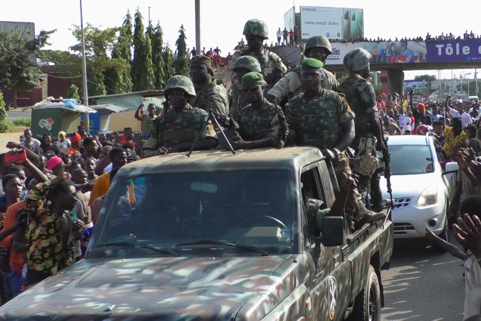 <p>Residents cheer at army soldiers as they celebrate the uprising in Conakry, Guinea on September 5, 2021.</p>
