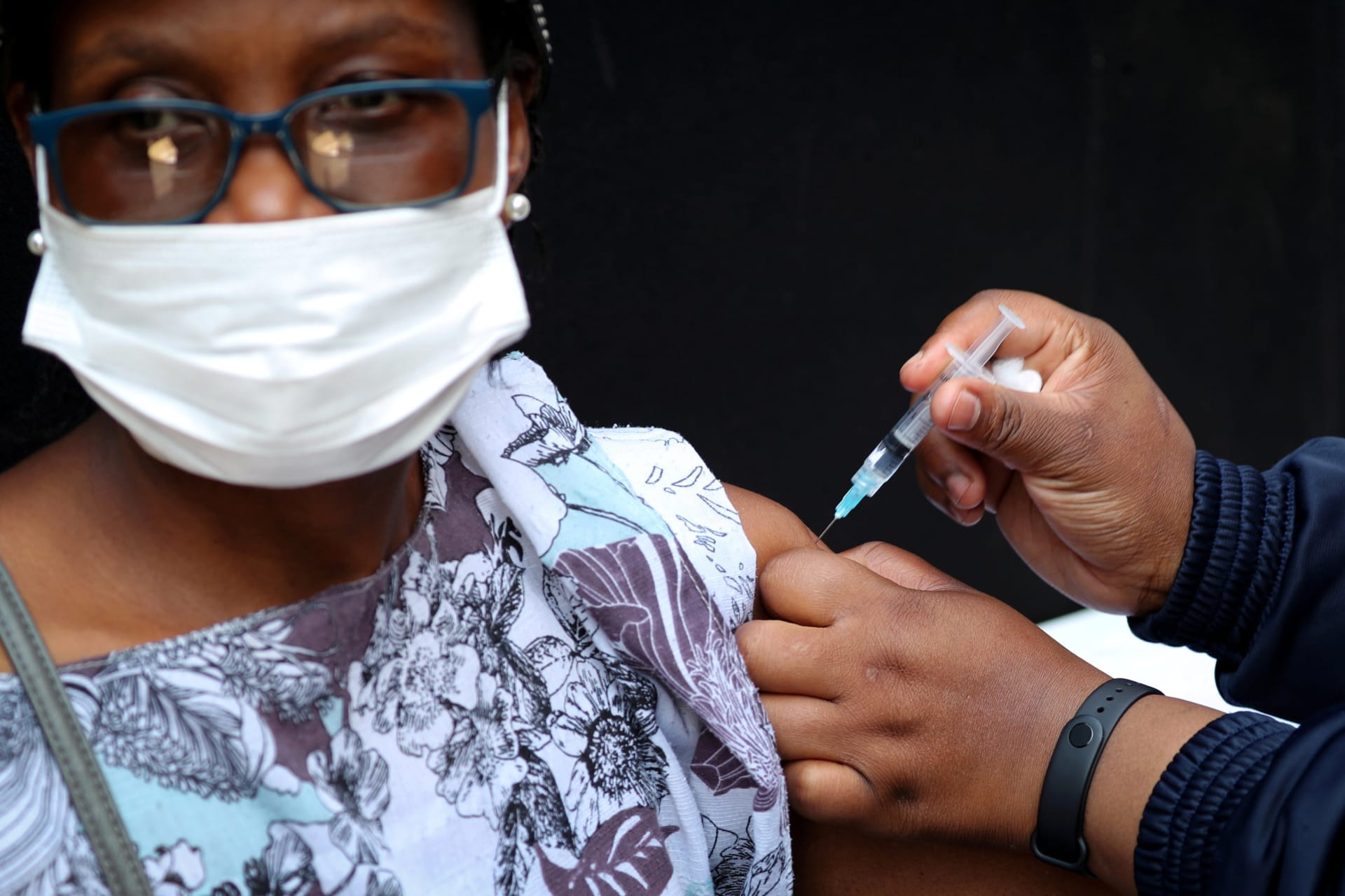 <p>A healthcare worker administers the Johnson & Johnson COVID-19 vaccination to a woman in Houghton, Johannesburg, South Africa on August 20, 2021.</p>
