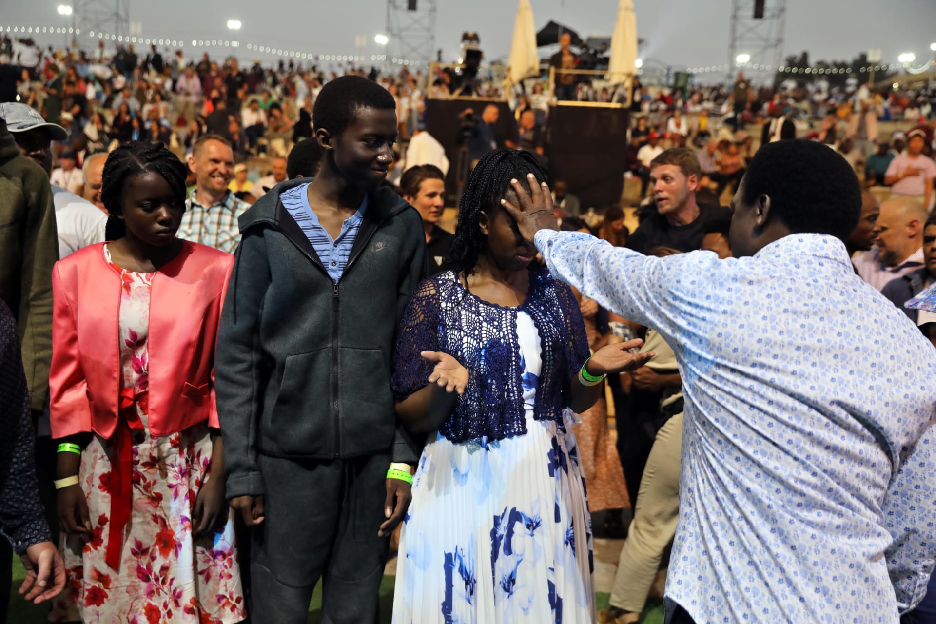 <p>T.B. Joshua, a Nigerian evangelical preacher places his hand over the face of a woman as he leads a religious retreat on Mount Precipice, Nazareth, northern Israel on June 23, 2019.</p>
