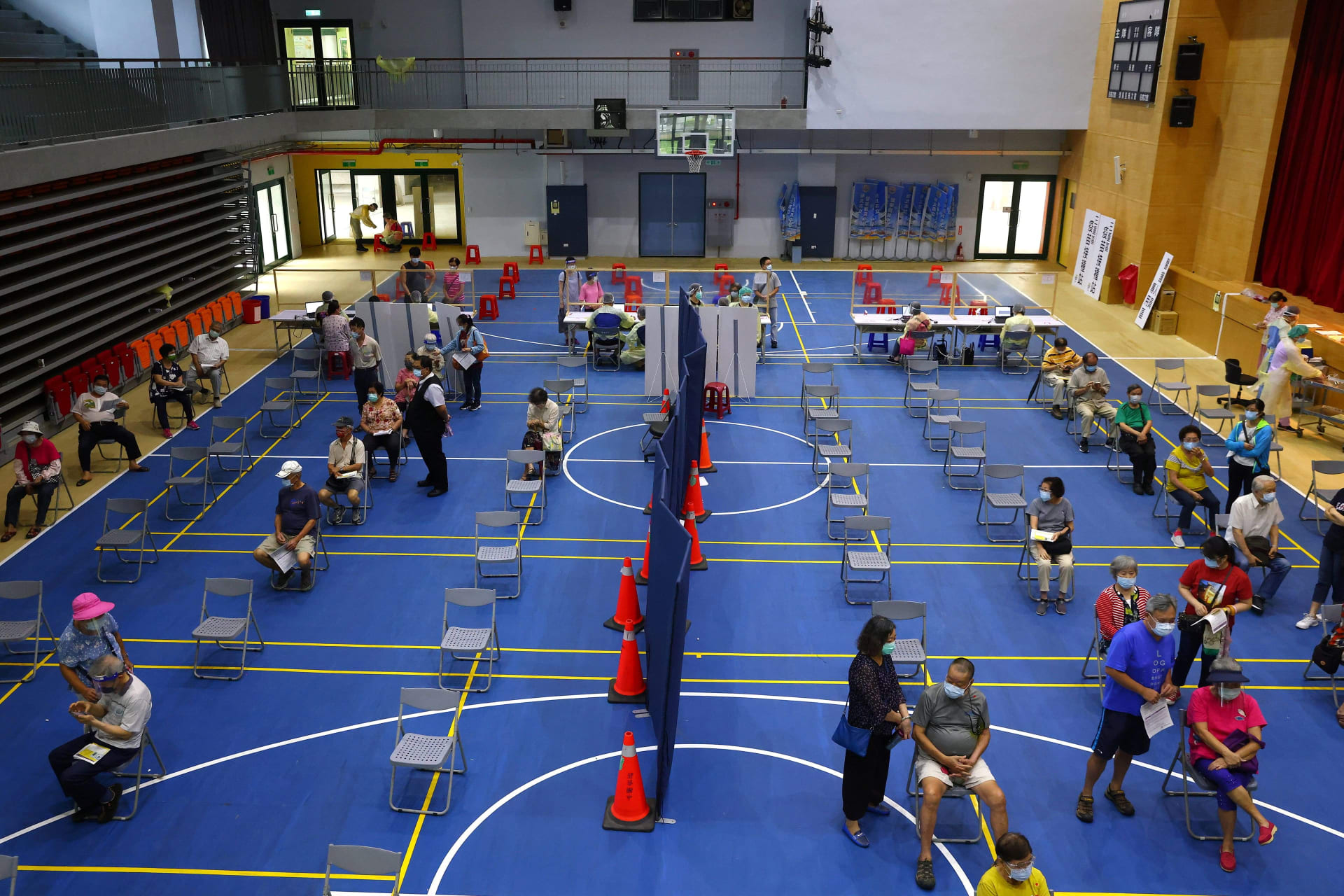 <p>People wait to receive a dose of the AstraZeneca vaccine against the coronavirus disease (COVID-19) at a stadium in New Taipei City, Taiwan on June 25, 2021.</p>
