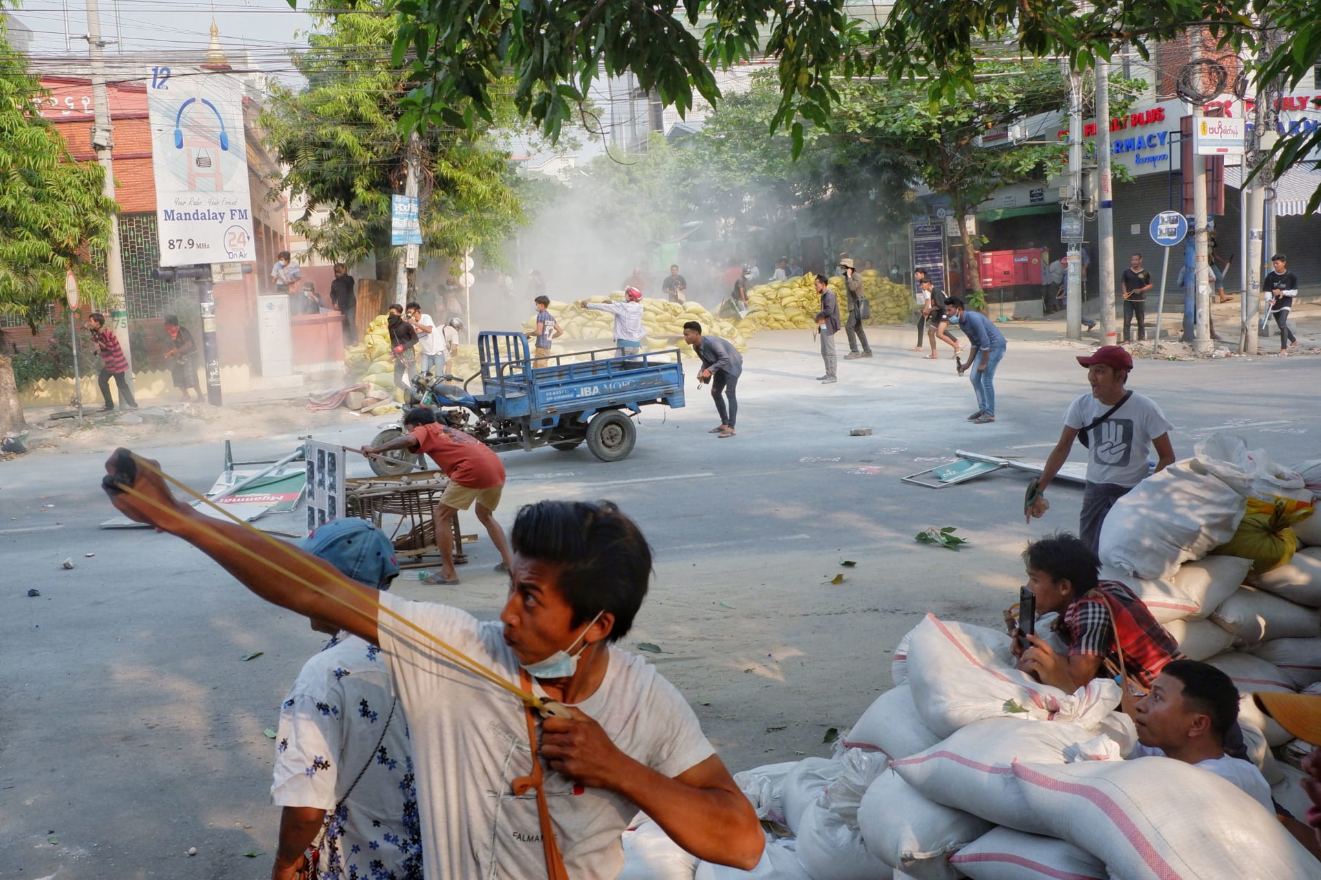 <p>A man uses a slingshot during the security force crack down on anti-coup protesters in Mandalay, Myanmar, on March 14, 2021.</p>
