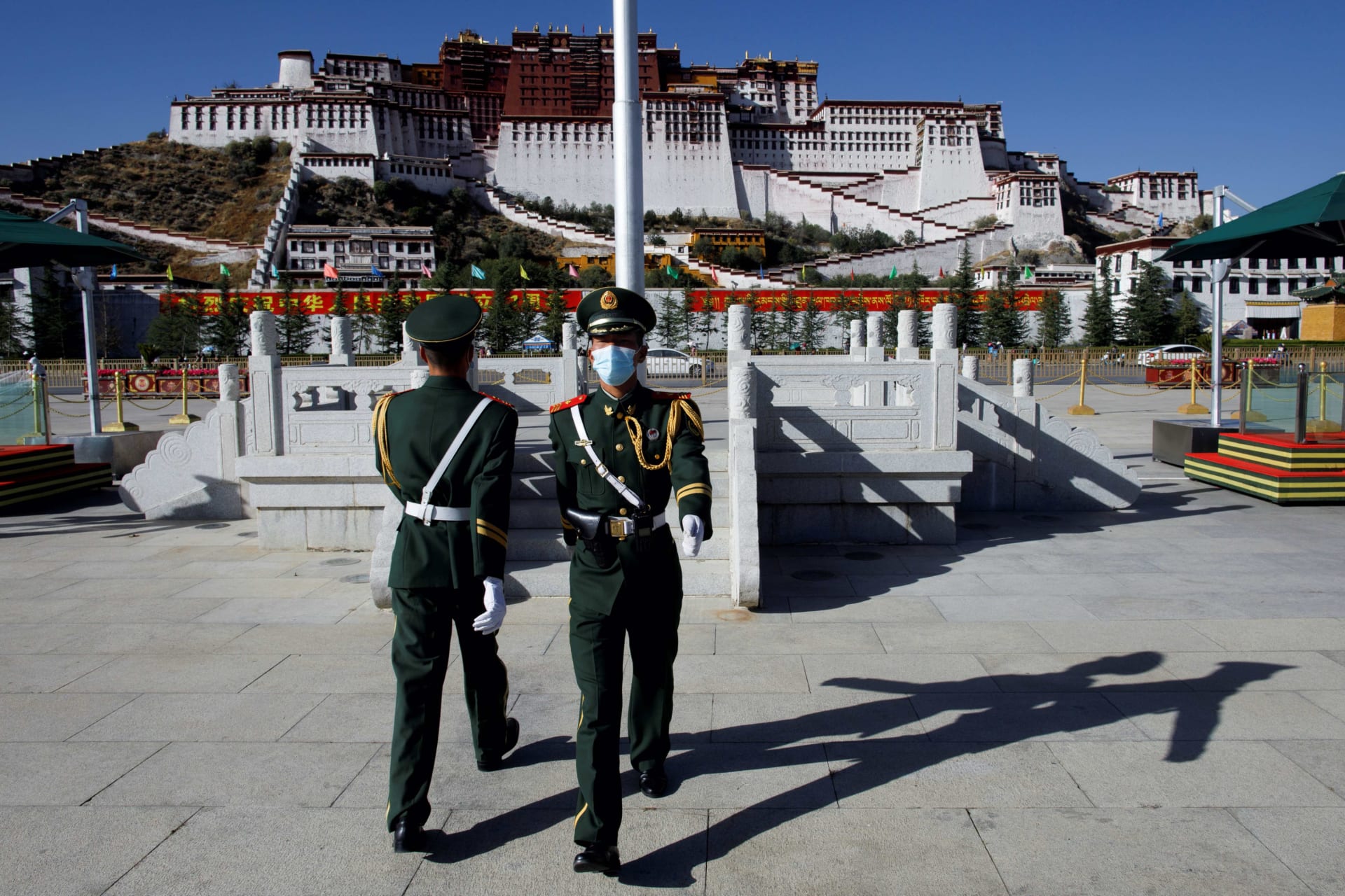 <p>Paramilitary police officers swap positions during a change of guard in front of Potala Palace in Lhasa on October 15, 2020.</p>
