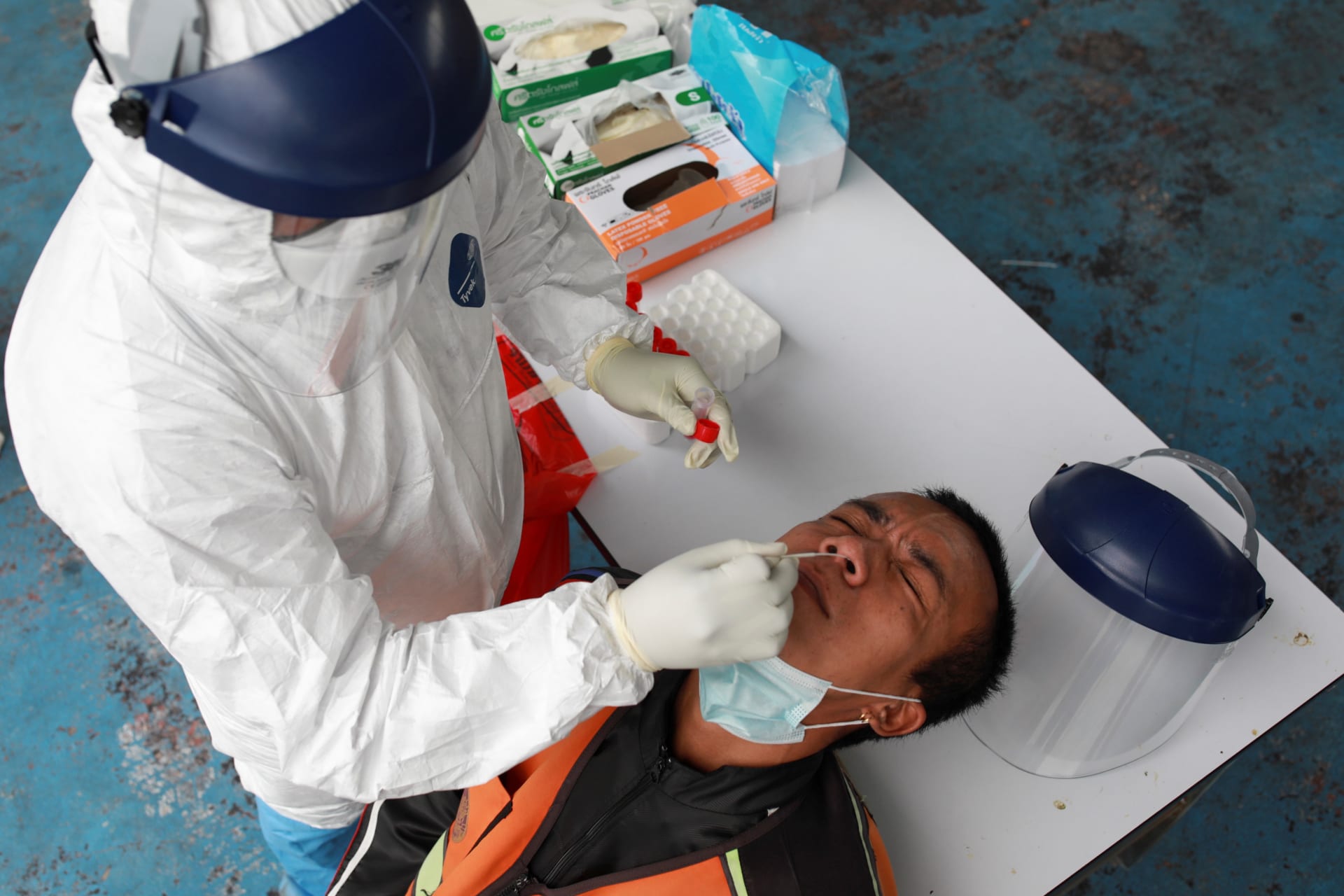 <p>A health worker takes a nasal swab sample from a man in Bangkok on May 4, 2021.</p>
