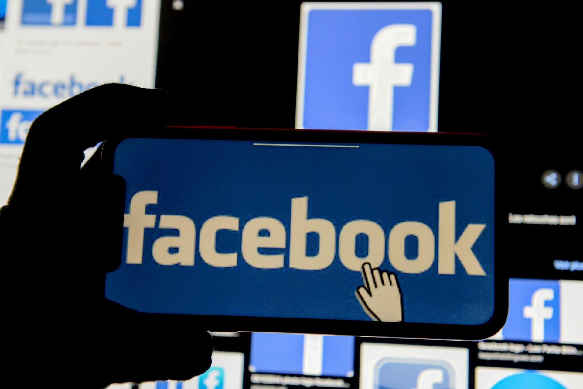 <p>The Facebook logo is displayed on a mobile phone.</p>
