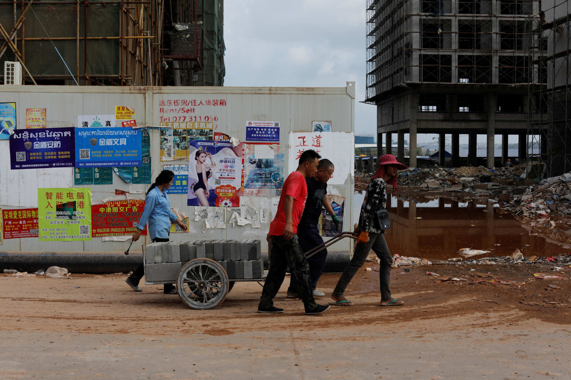 <p>Construction workers move cement blocks in Chinatown, Sihanoukville, Cambodia, on May 18, 2019.</p>
