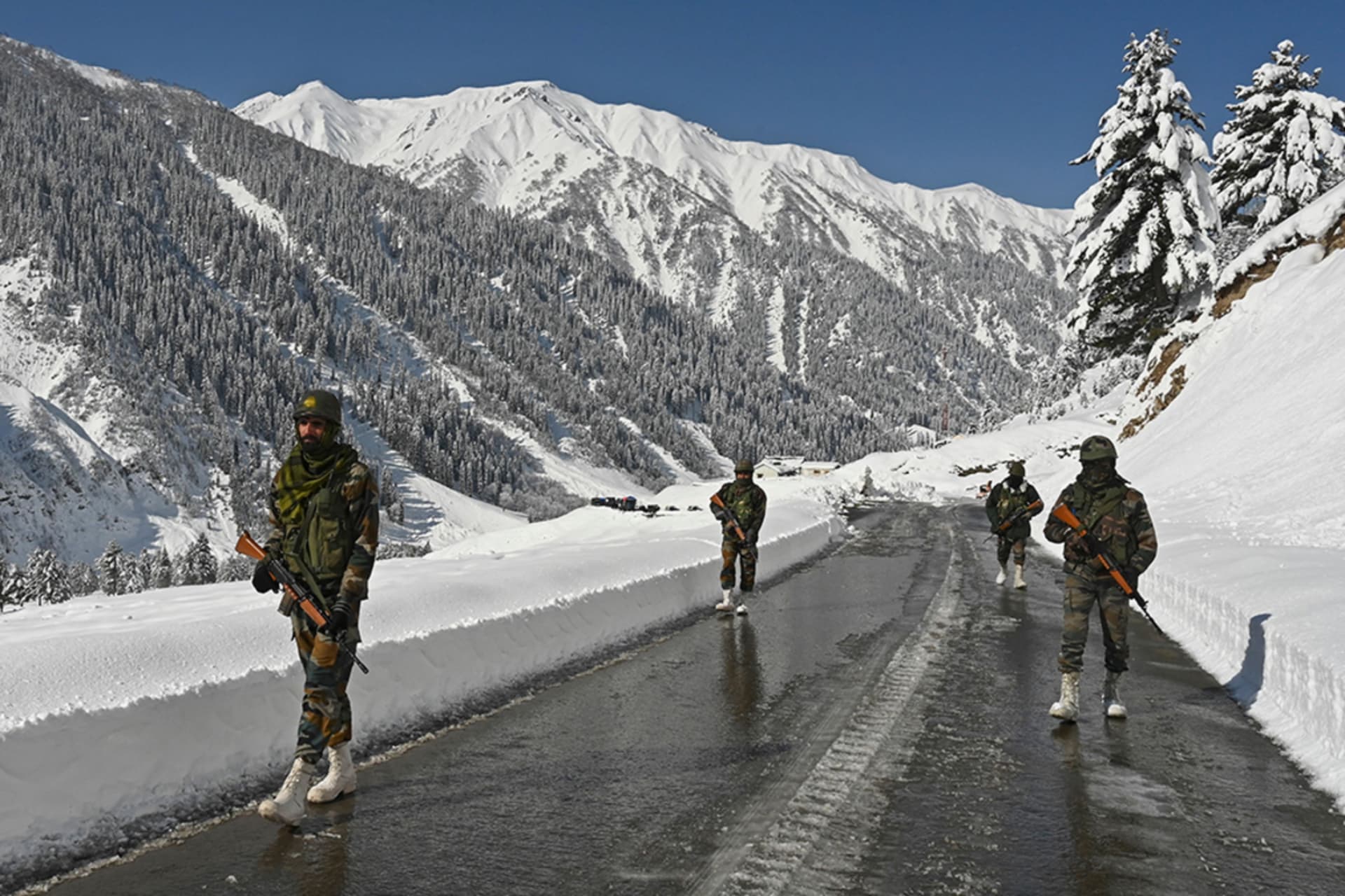 <p>Indian army soldiers walk along a road near Zojila mountain pass that connects Srinagar to the union territory of Ladakh, bordering China, on February 28, 2021.</p>
