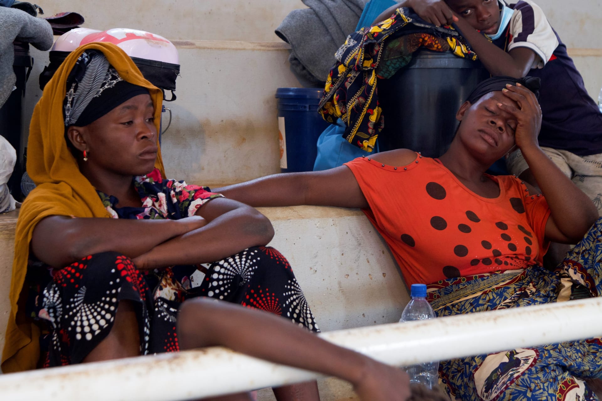 <p>Women sit inside a displacement center after fleeing an attack claimed by Islamic State-linked insurgents on the town of Palma, in Pemba, Mozambique on April 2, 2021.</p>
