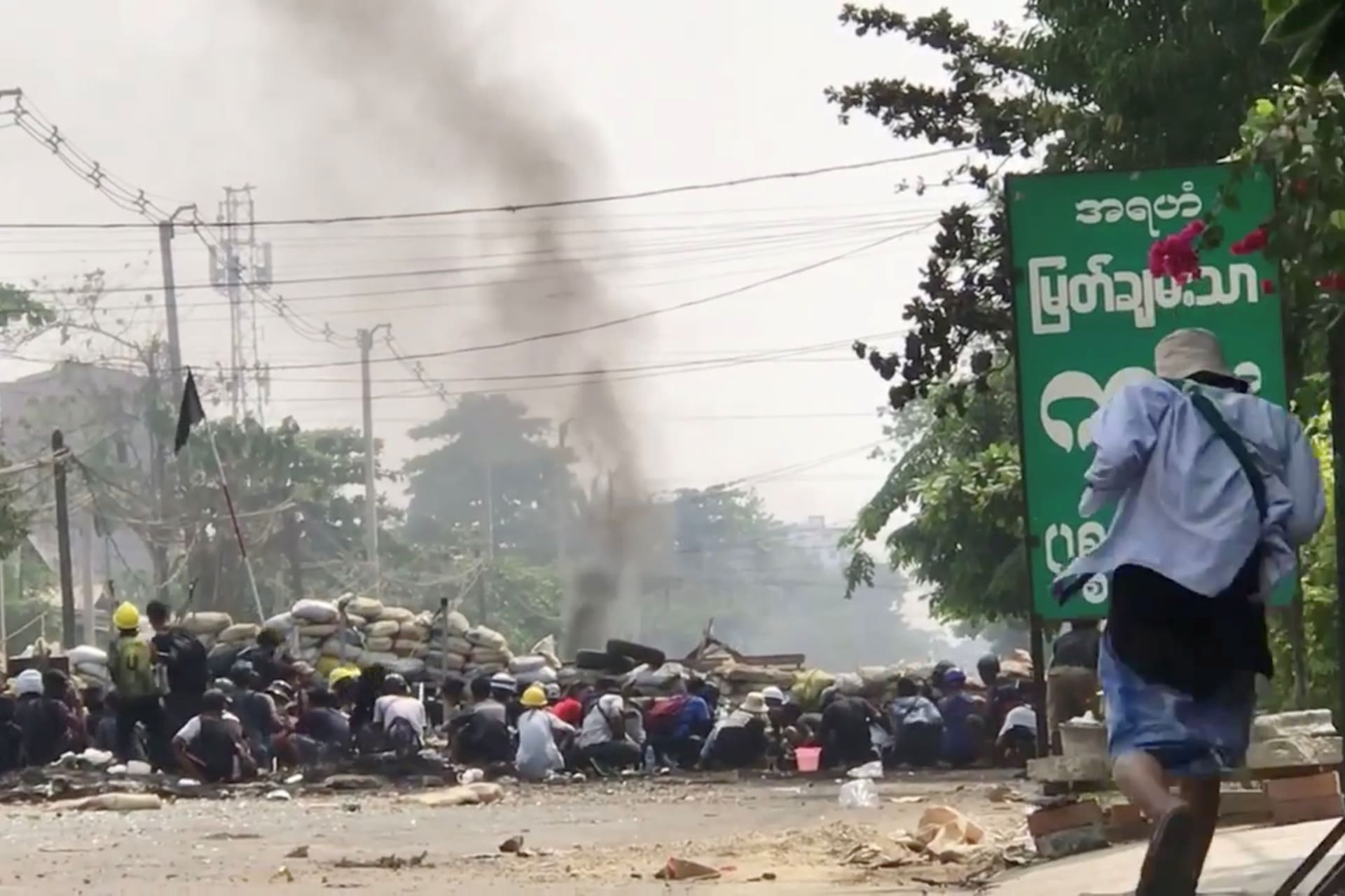 <p>Demonstrators hide behind a barricade during protests against the military coup in Yangon, Myanmar, on March 28, 2021, in this screen grab taken from a social media video obtained by Reuters.</p>