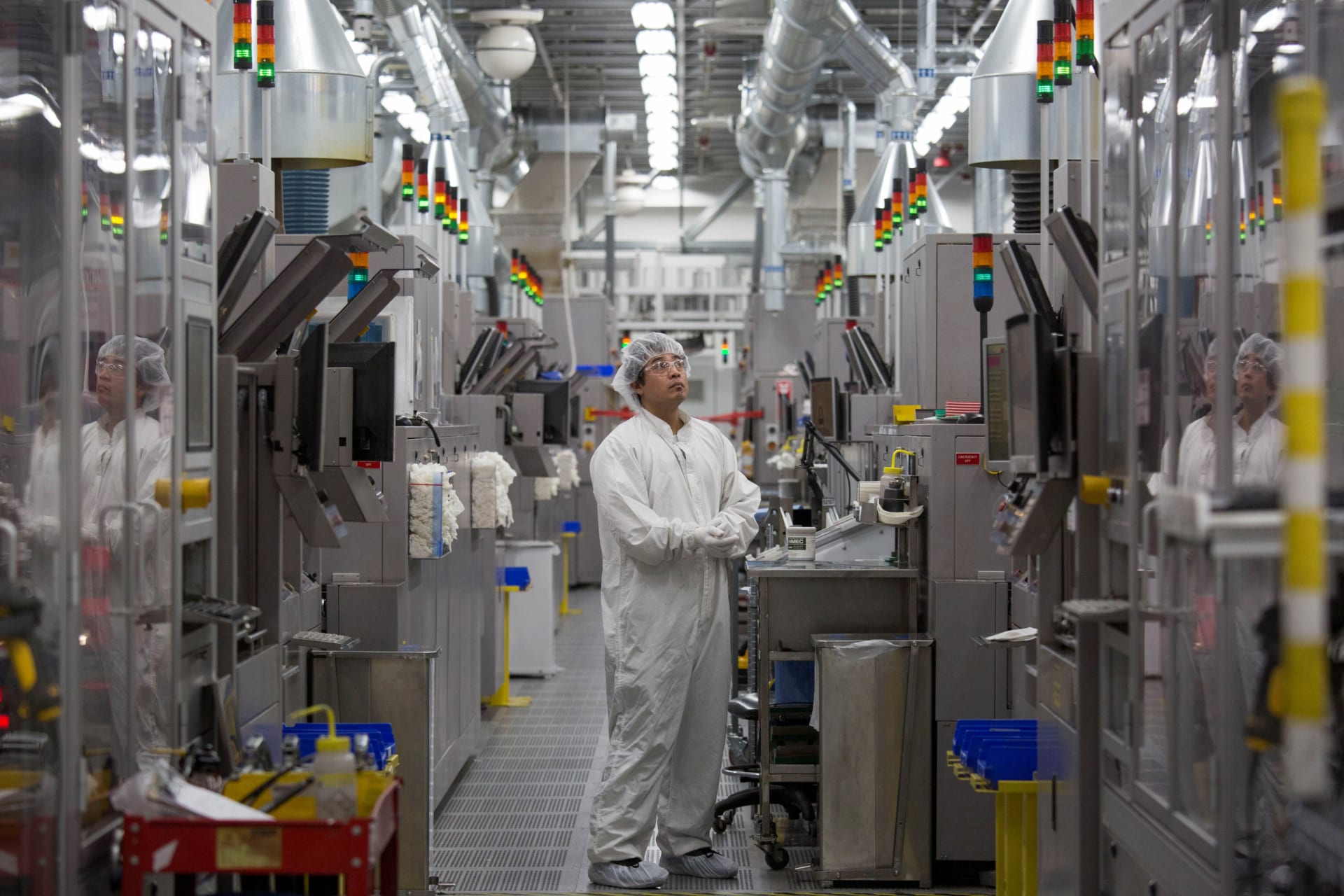 <p>Production operator Sammy Blanco monitors multi colored lights atop automated machines at the SolarWorld solar panel factory in Hillsboro, Oregon, U.S.</p>