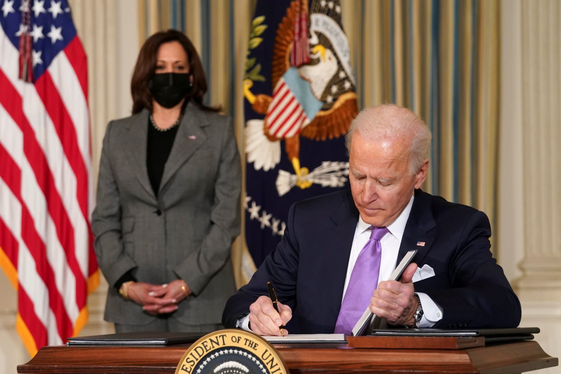 <p>Vice President Kamala Harris looks on as President Joe Biden signs executive orders addressing racial equality. </p>
