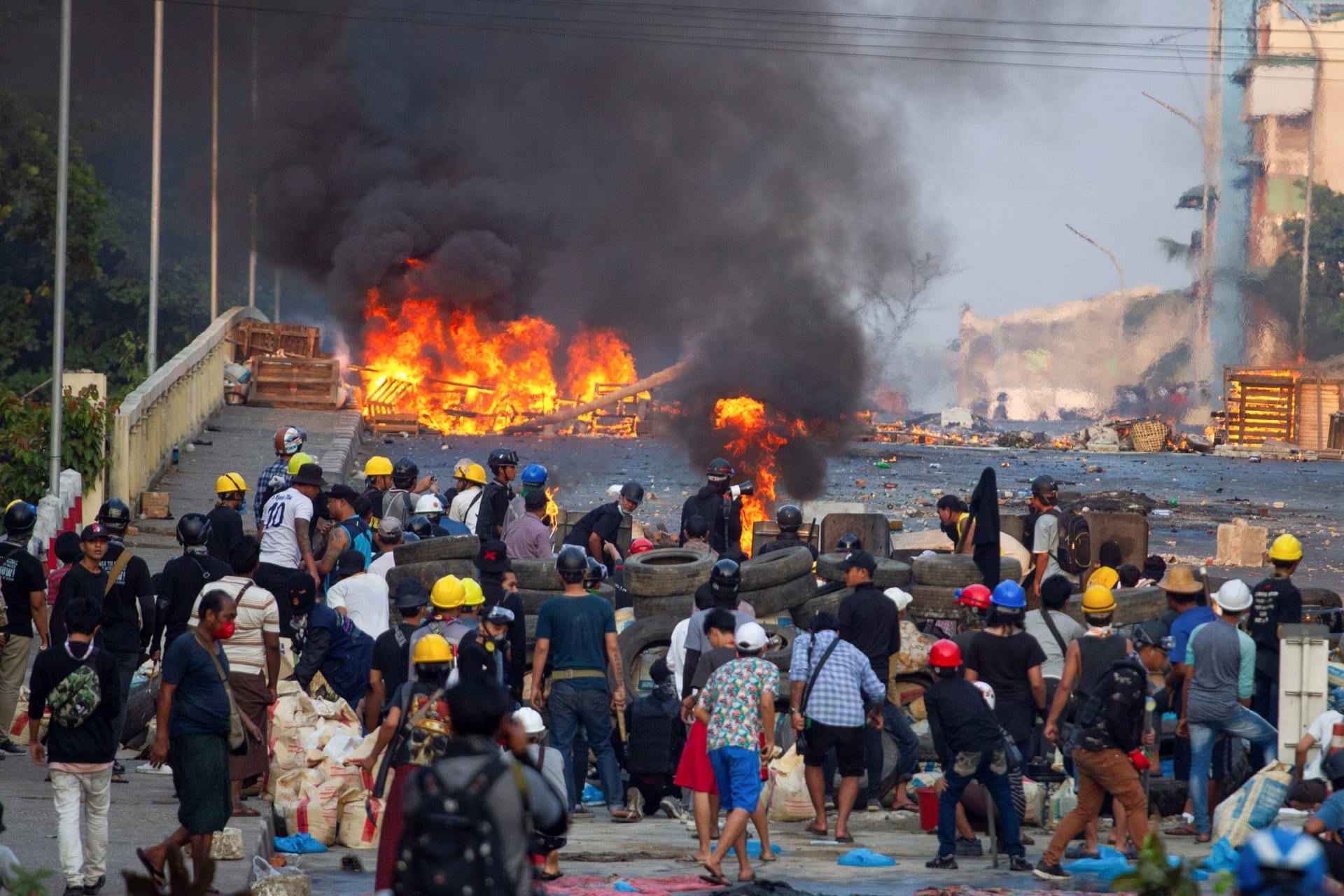 <p>Anti-coup protesters stand at a barricade as they clash with security forces on Bayint Naung Bridge in Mayangone, Yangon, Myanmar, on March 16, 2021.</p>
