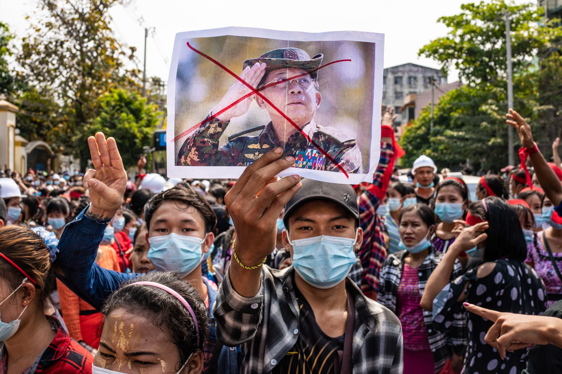 <p>A protester holds an image of Senior General Min Aung Hlaing during an anti-coup march in February 2021.</p>
