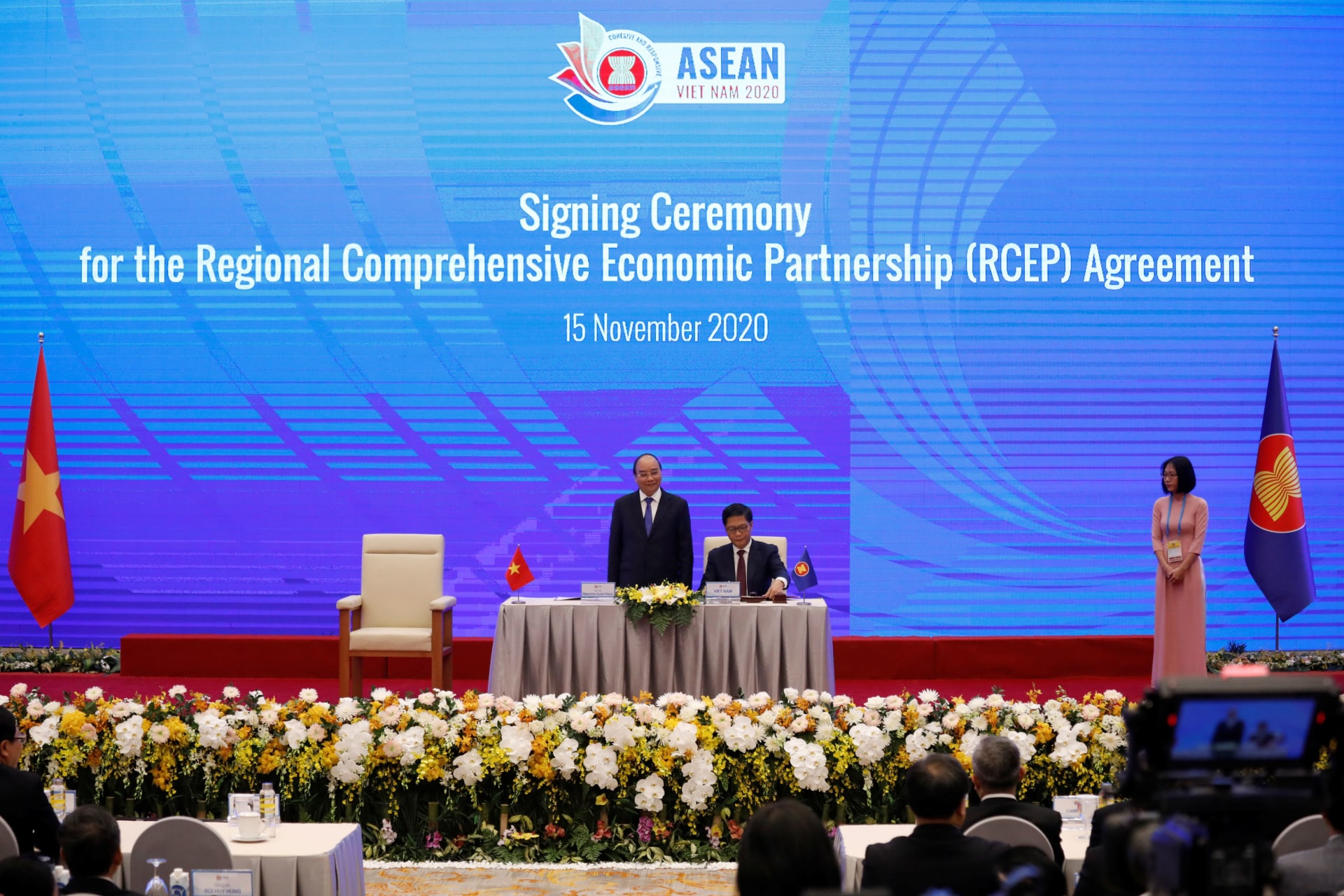 <p>Vietnam’s Industry and Trade Minister Tran Tuan Anh (C) signs as Vietnam’s Prime Minister Nguyen Xuan Phuc (L) witnesses during the signing ceremony of the Regional Comprehensive Economic Partnership (RCEP) Agreement during the 37th ASEAN Summit in Hanoi,</p>
