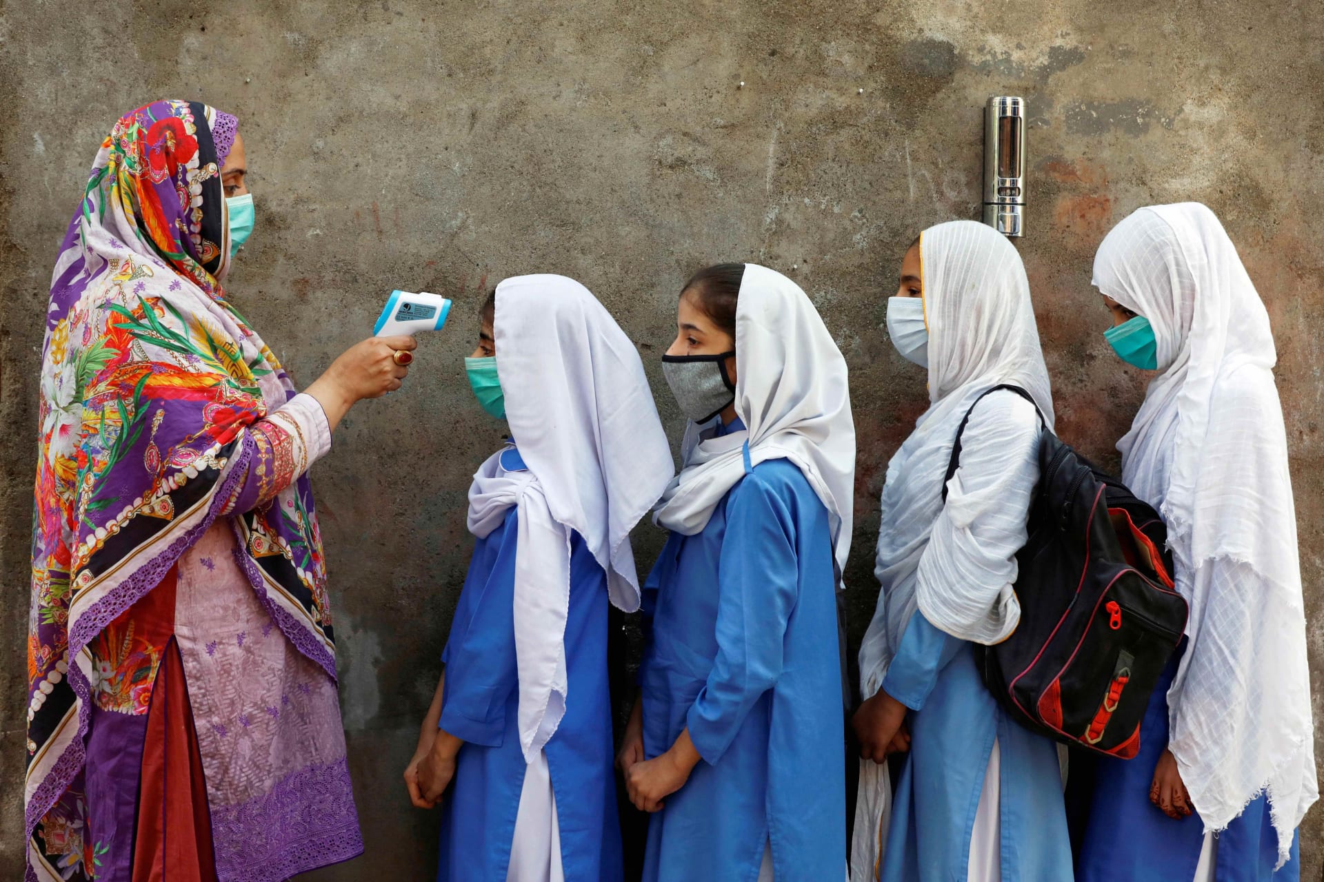 <p>Students wear face masks during temperature checks in Peshawar, Pakistan on September 23, 2020. Fayaz Aziz/Reuters</p>
