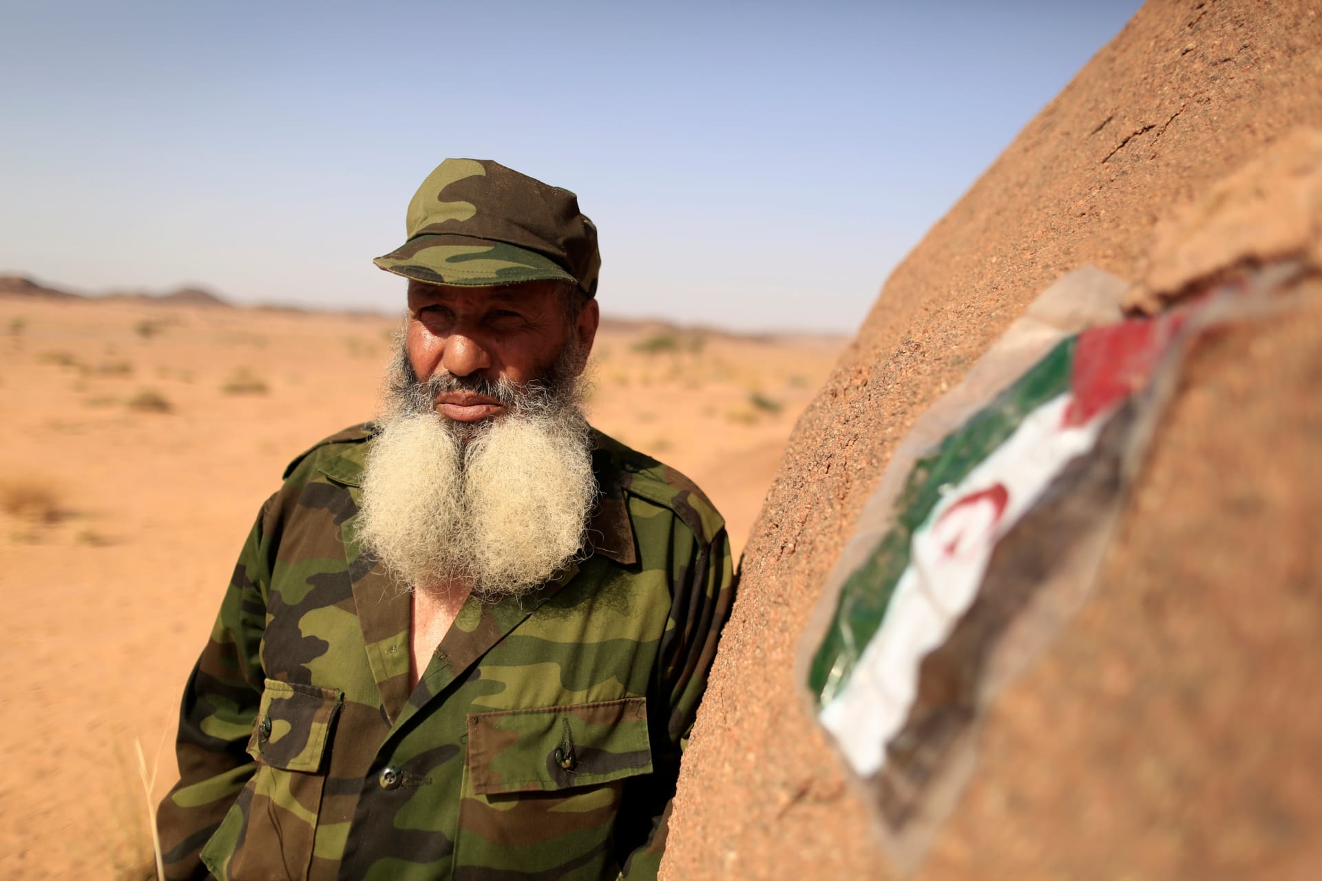 <p>A Polisario fighter stands next to a Sahrawi Arab Democratic Republic flag at a forward base on the outskirts of Tifariti, Western Sahara, September 9, 2016.</p>
