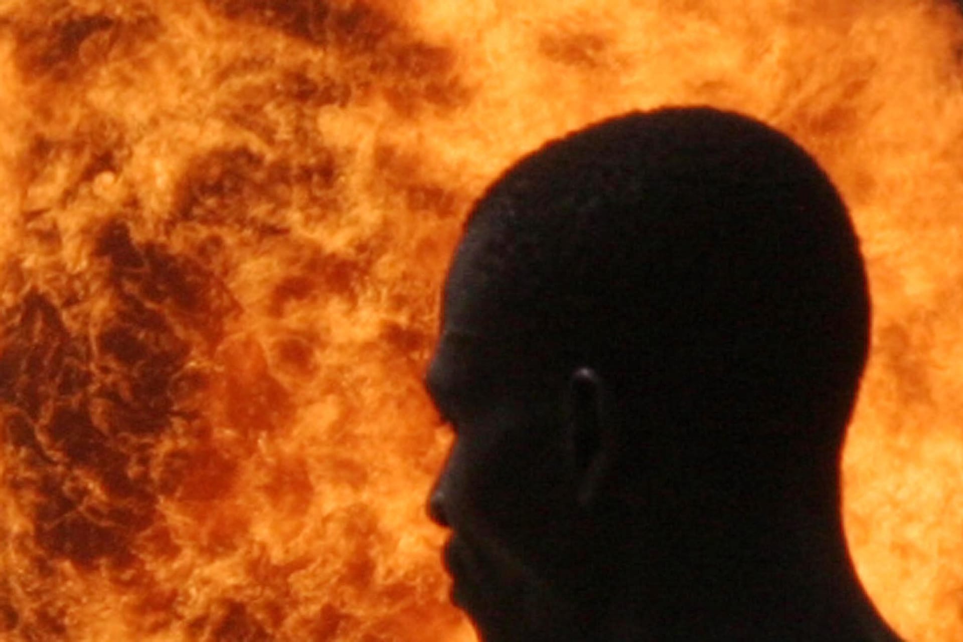 <p>A farmer walks past gas flare at Utorogu flow station in Otujerenvwi, 50 kilometers (31 miles) from Warri in the oil-rich Niger delta region of Nigeria, on December 2, 2004.</p>
