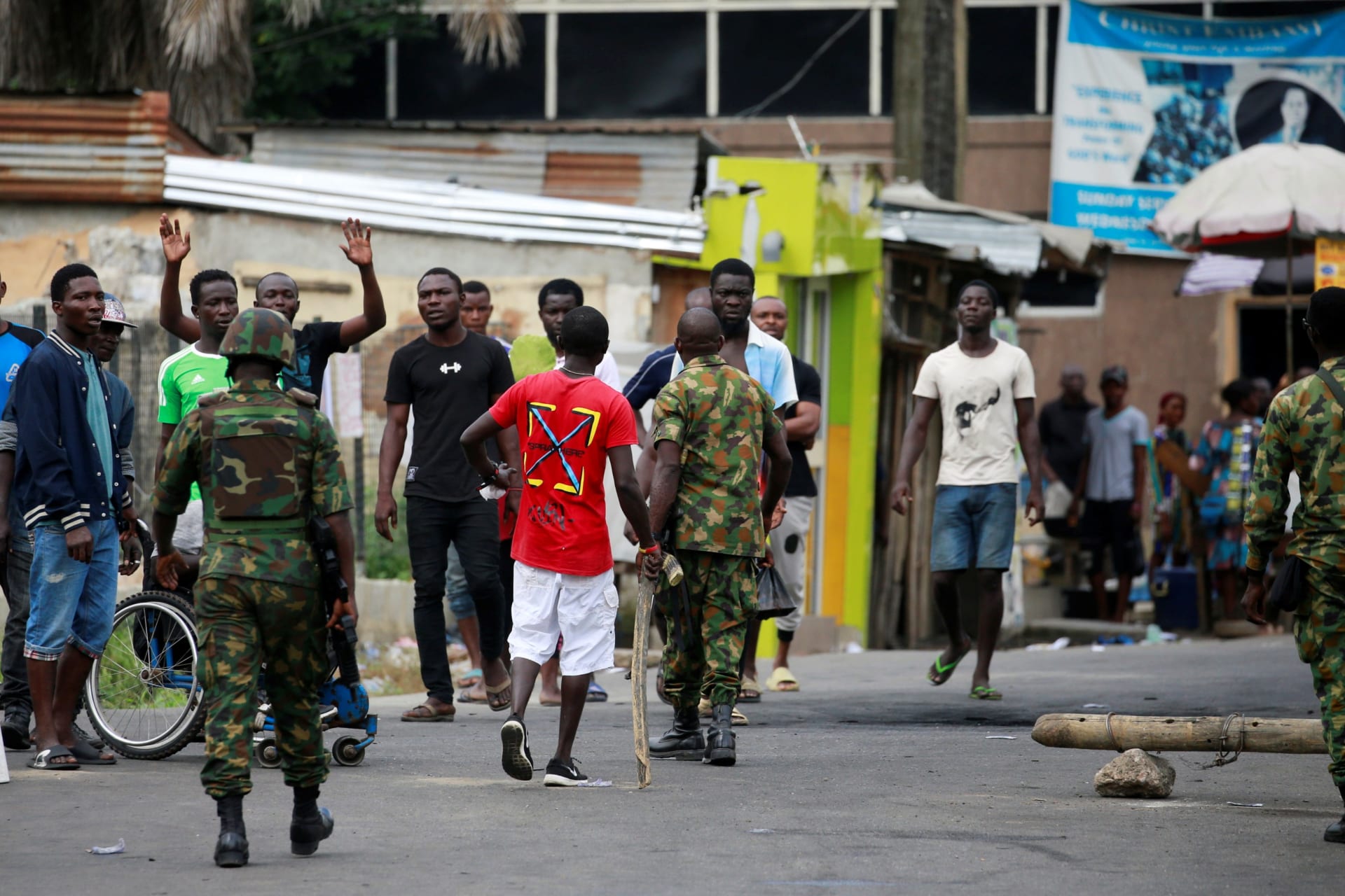 <p>Military personnel move towards people standing along a blocked road in Ikeja, as Nigeria’s Lagos state remains under curfew, Nigeria on October 23, 2020.</p>