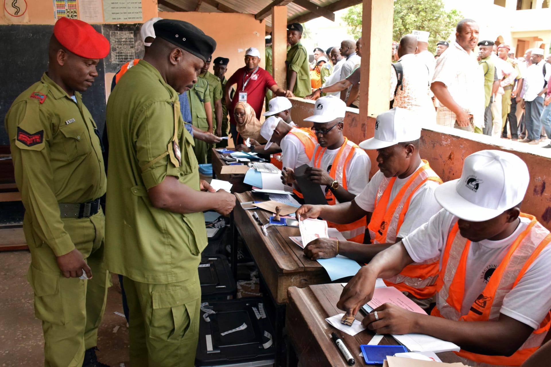 <p>Tanzanian government officials are processed before casting their ballots at a polling centre during the early voting for essential workers at the presidential and parliamentary polls in the semi-autonomous island of Zanzibar, Tanzania October 27, 2020</p>
