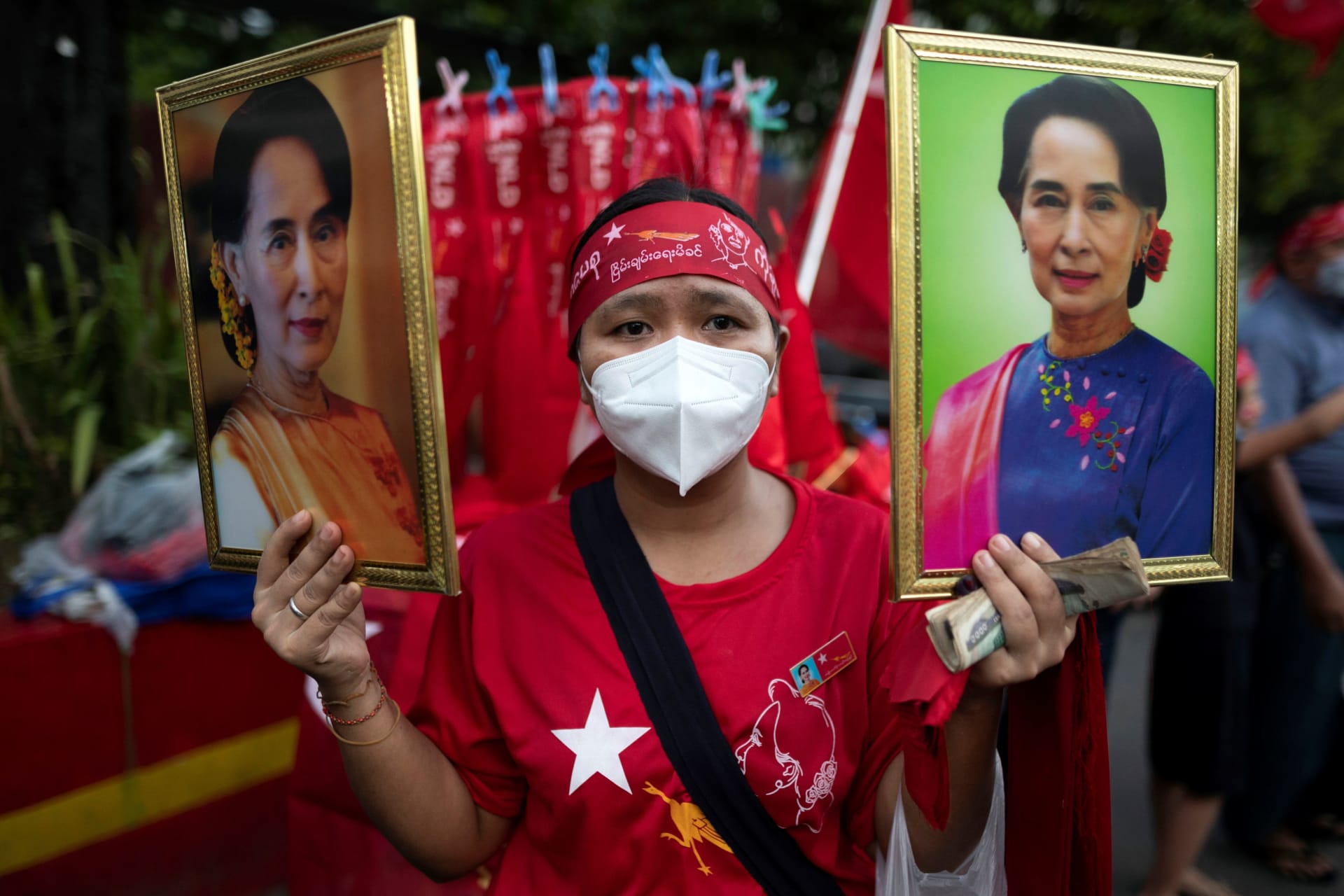 <p>A supporter of National League for Democracy (NLD) holds two portraits of Myanmar State Counselor Aung San Suu Kyi as people gather to celebrate at party headquarters after the general election in Yangon, Myanmar, on November 9, 2020.</p>
