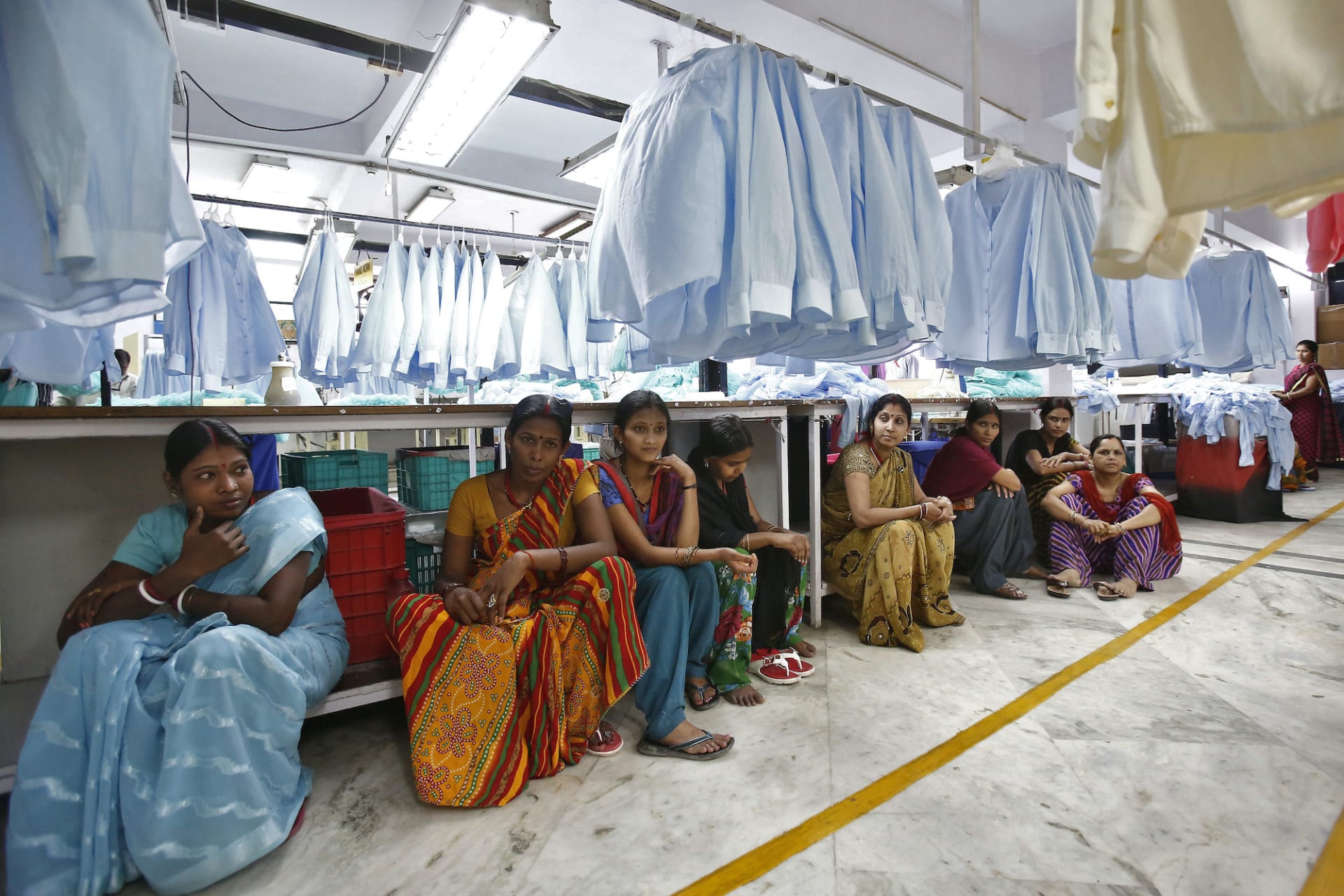 <p>Employees sit during their lunch inside a textile mill of Orient Craft Ltd. at Gurgao in Haryana, May 5 2014</p>