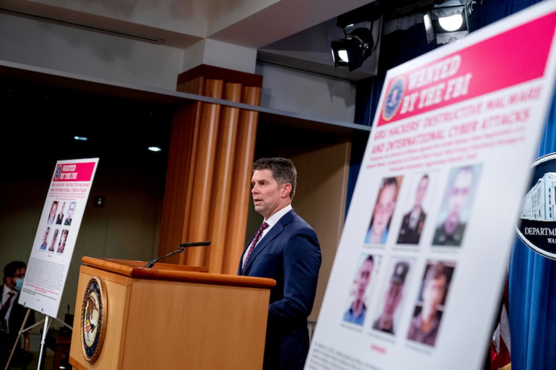 <p>Posters showing six wanted Russian military intelligence officers are displayed as FBI Deputy Director David Bowdich speaks at a news conference at the Department of Justice, in Washington, U.S., October 19, 2020.</p>
