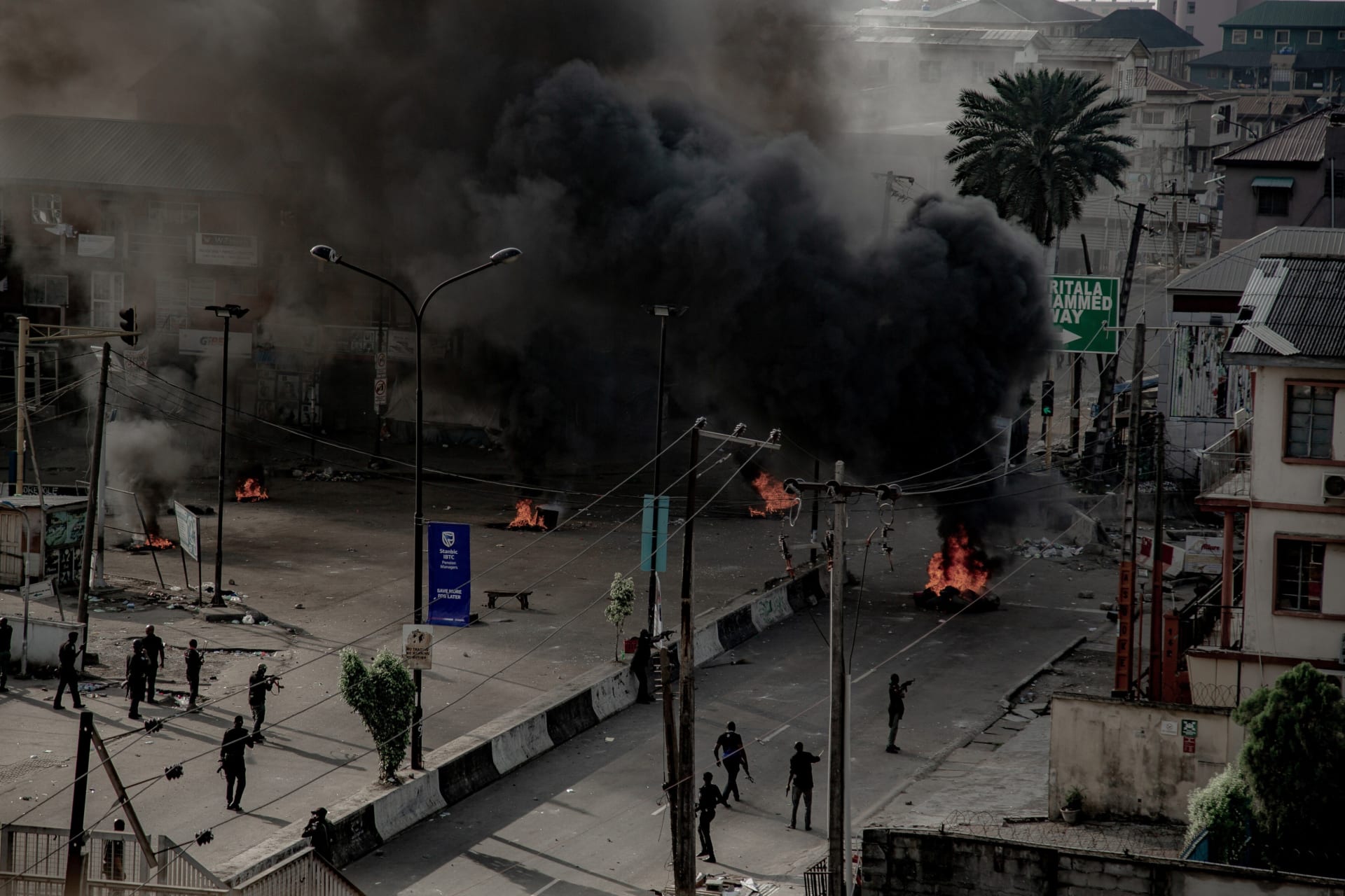<p>Armed men are seen near burning tires on the street, in Lagos, Nigeria on October 21, 2020.</p>

