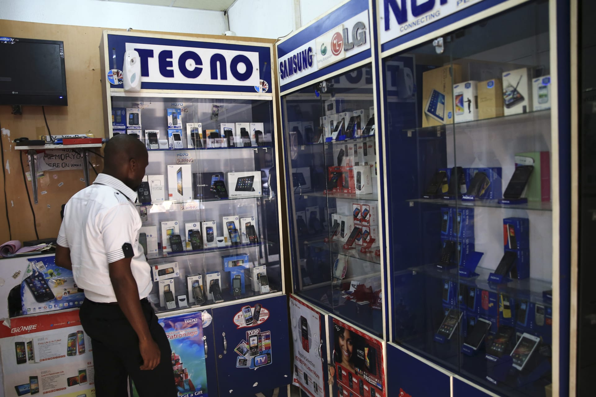 <p>A man looks at smartphones on display at a shop.</p>
