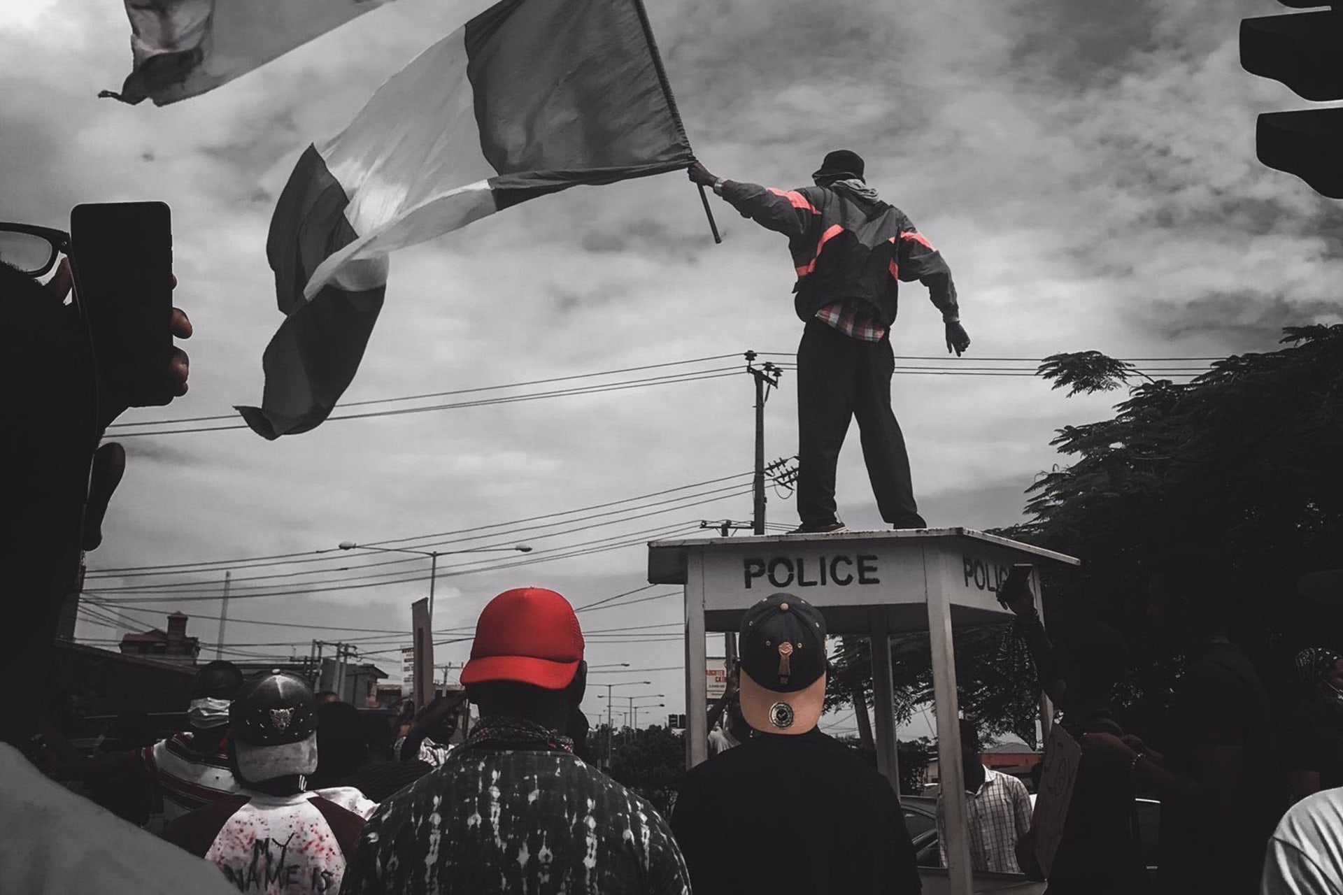 <p>A protester stands atop a police structure in Ikeja, capital of Lagos state, during #EndSARS demonstrations on October 11, 2020.</p>
