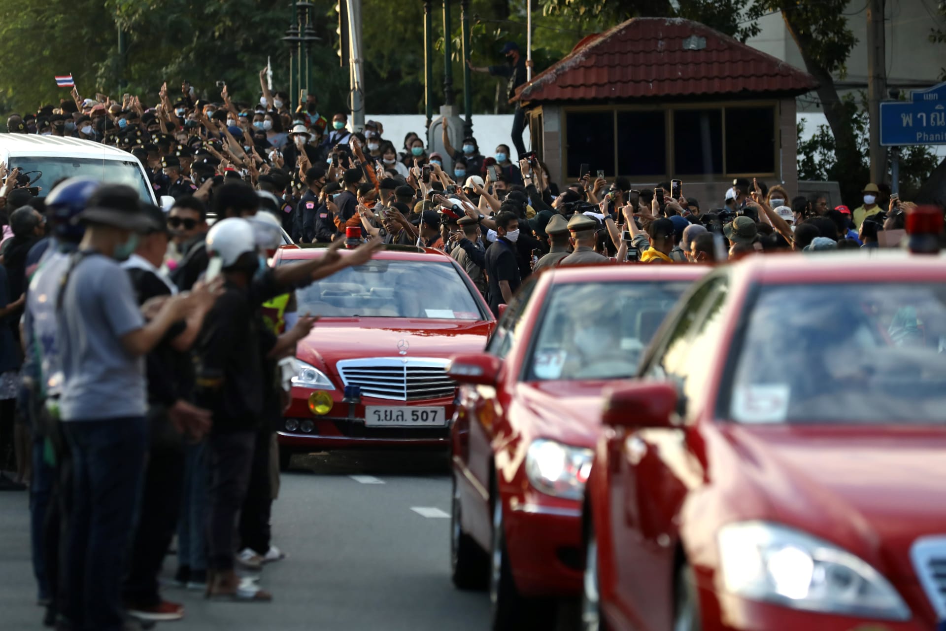 <p>Pro-democracy demonstrators flash a three-finger salute as a royal motorcade drives past during a Thai antigovernment mass protest, on the 47th anniversary of the 1973 student uprising, in Bangkok, Thailand on October 14, 2020. </p>
