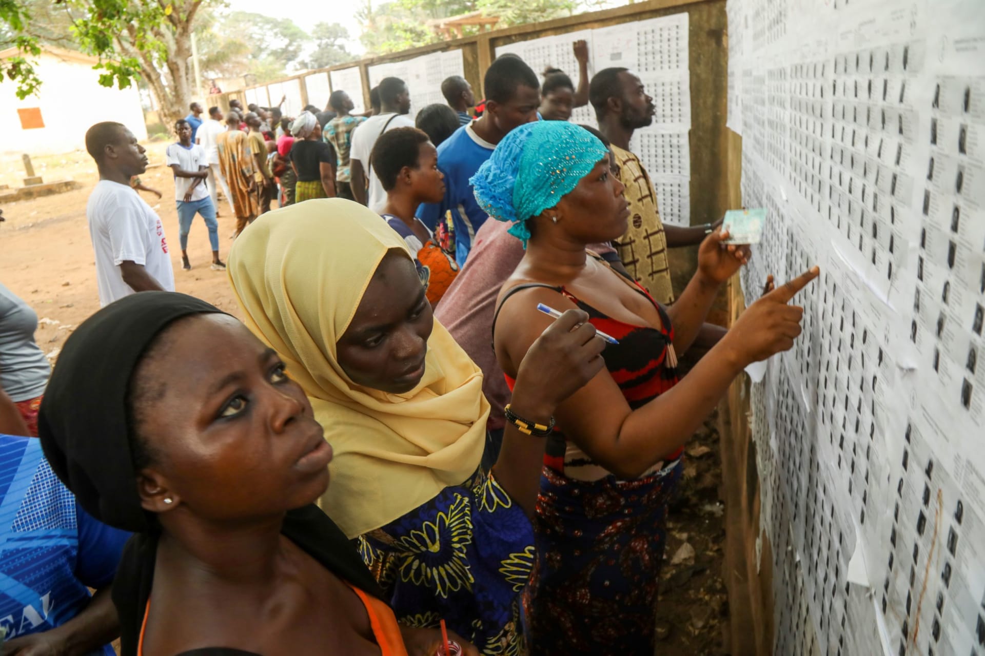 <p>Women in Togo are checking their names at a polling location.</p>
